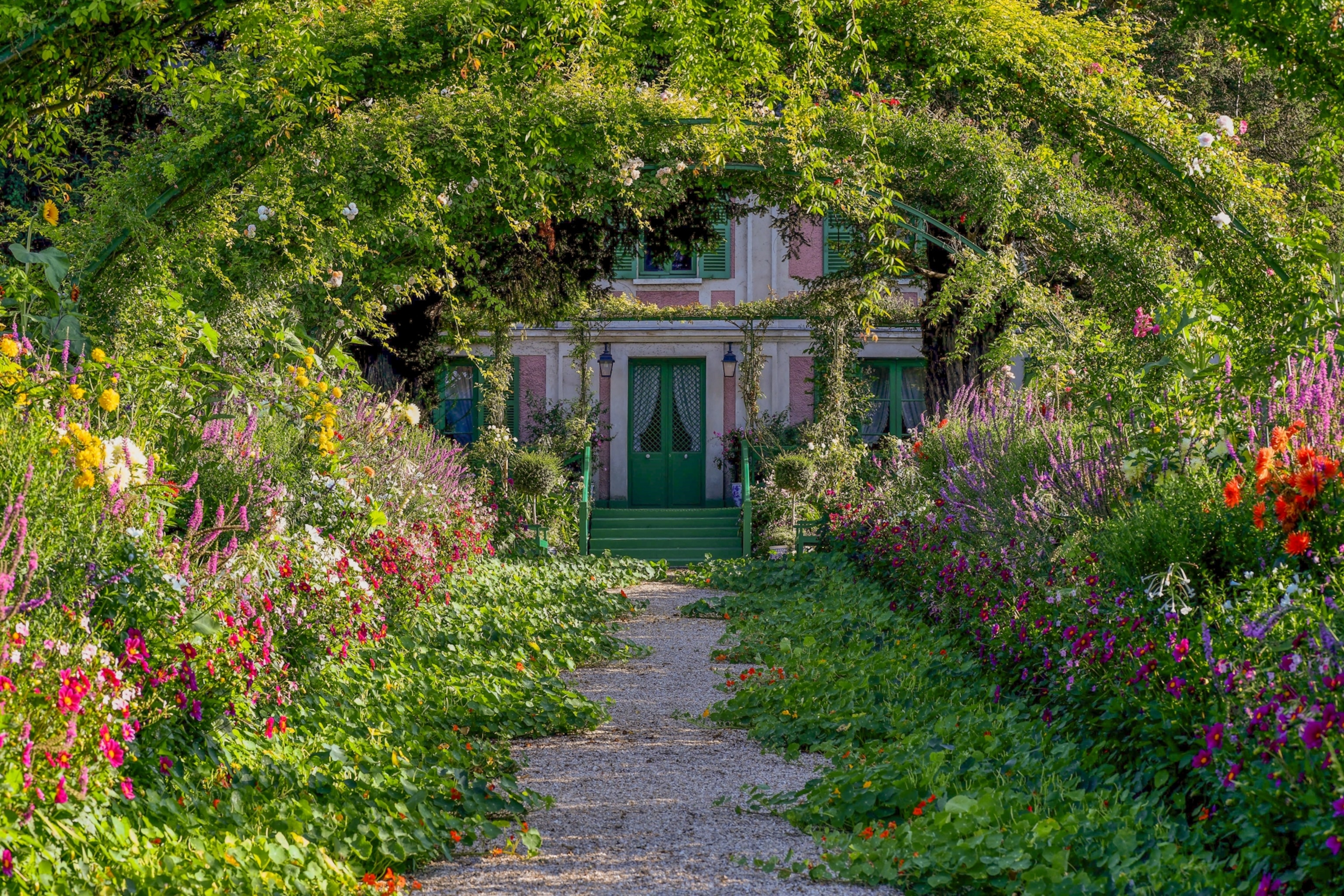 Path surrounded with flower leads to French painter Claude Monet's Inspired garden and house in Giverny, France