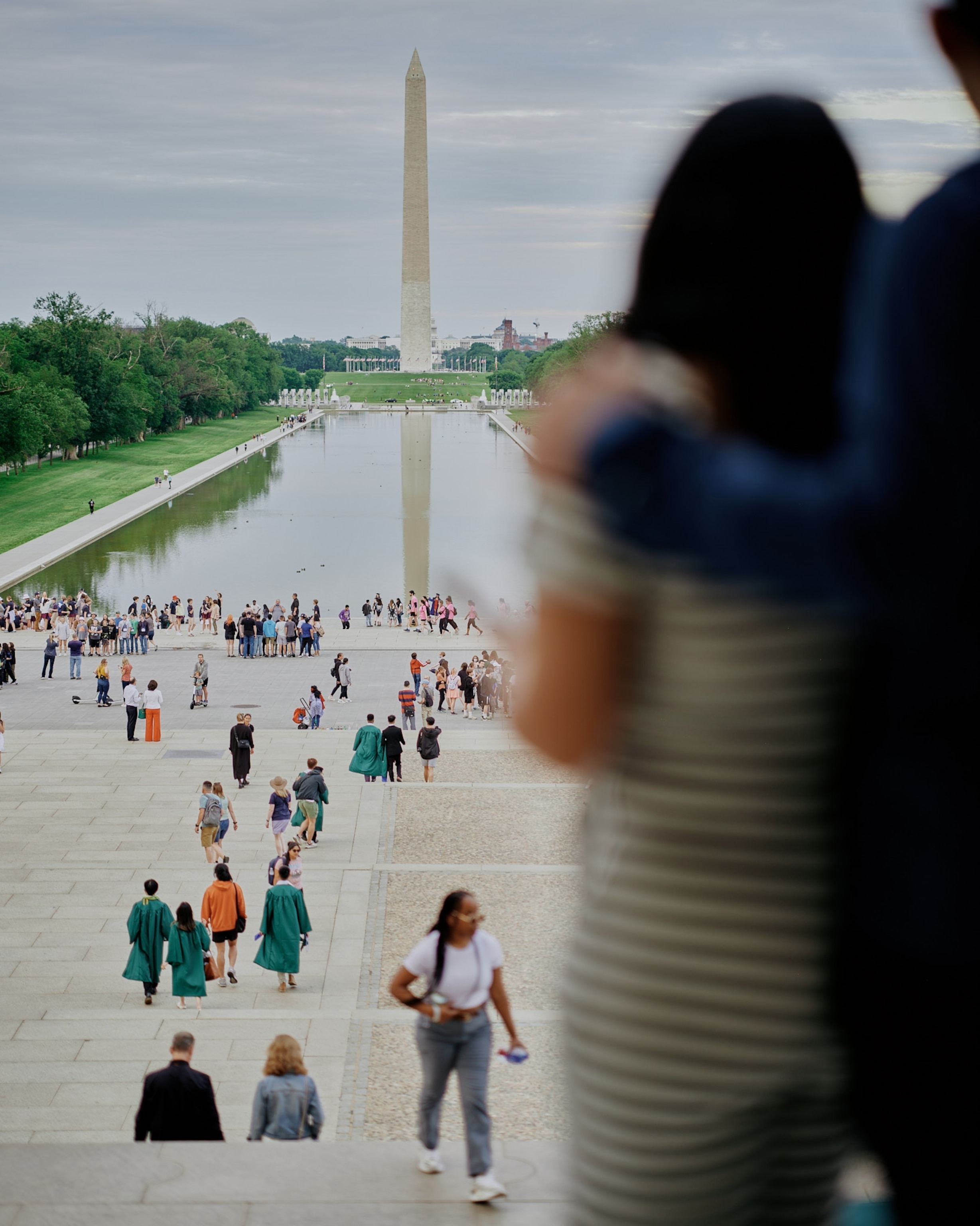 People look out towards the reflecting pool from the top of the steps of the Lincoln Memorial in Washington D.C.