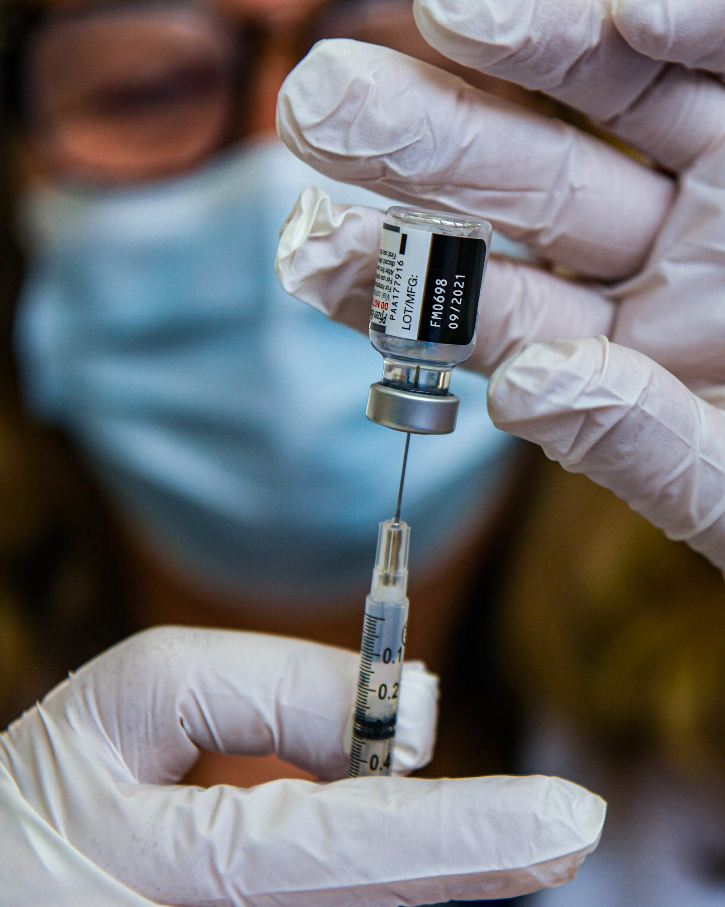 A close-up view as a pharmacist extracts a COVID-19 booster vaccination from a vial.