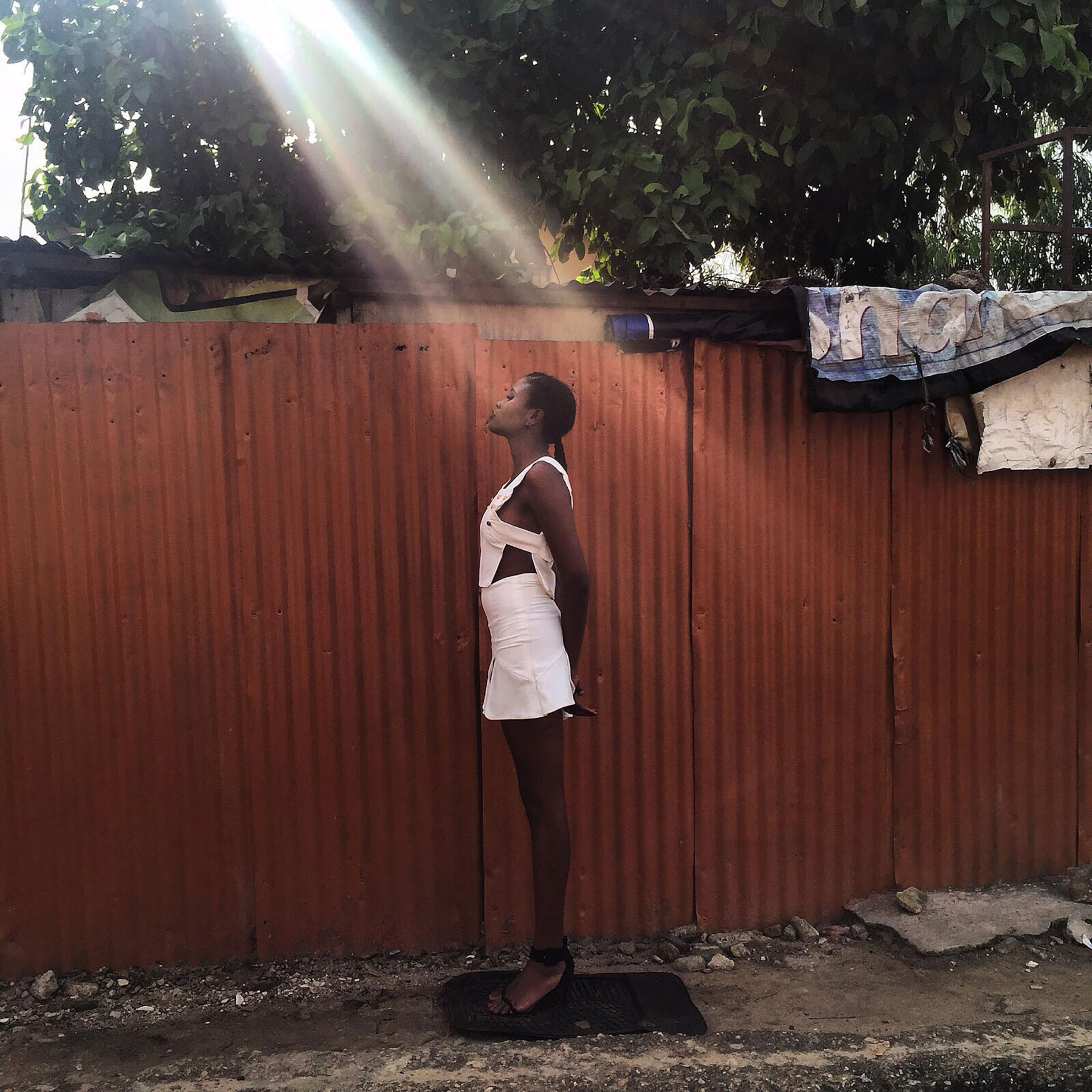 a model catches a break of light through the trees in Lagos, Nigeria
