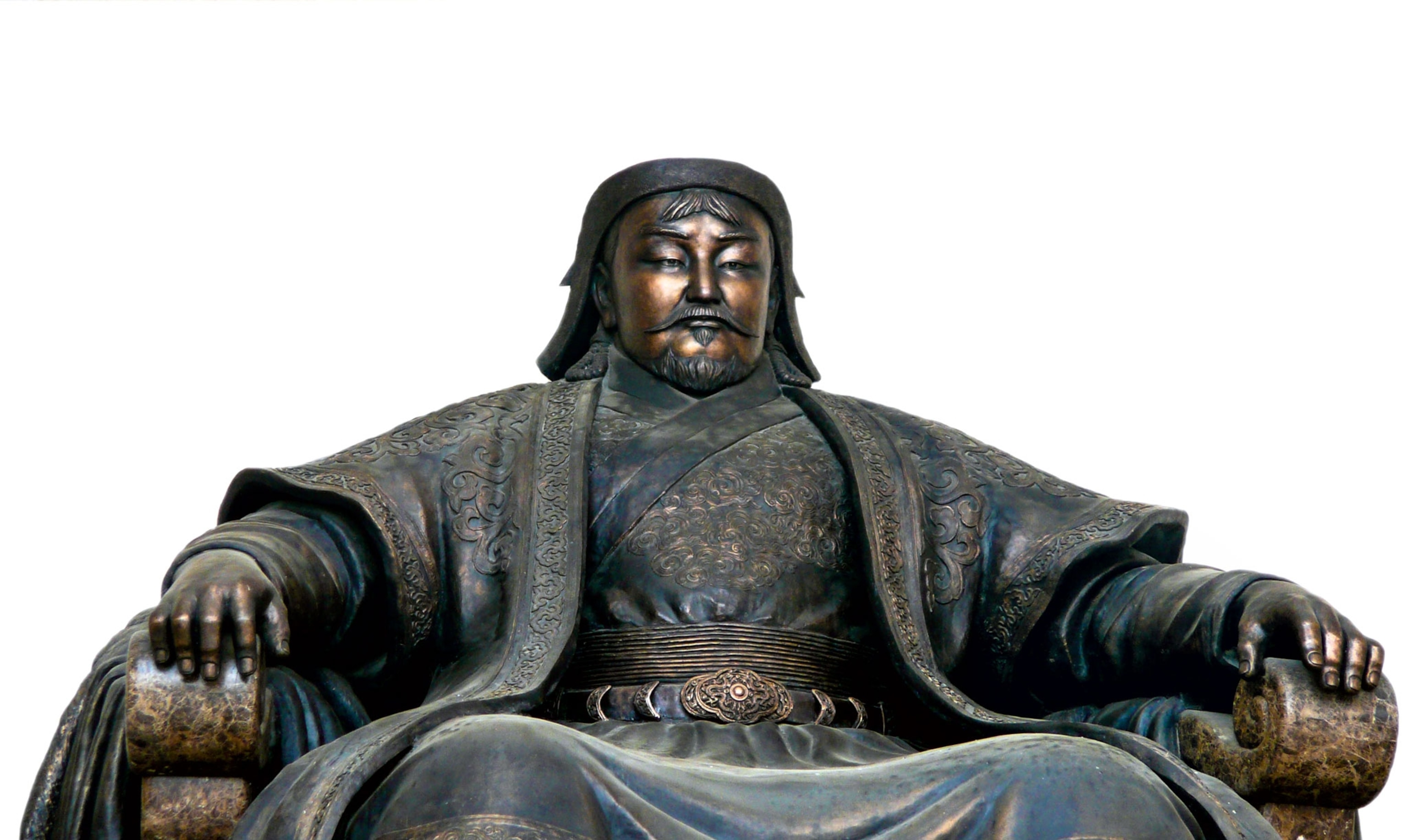 a dark metal statue of a seated figure in a robe