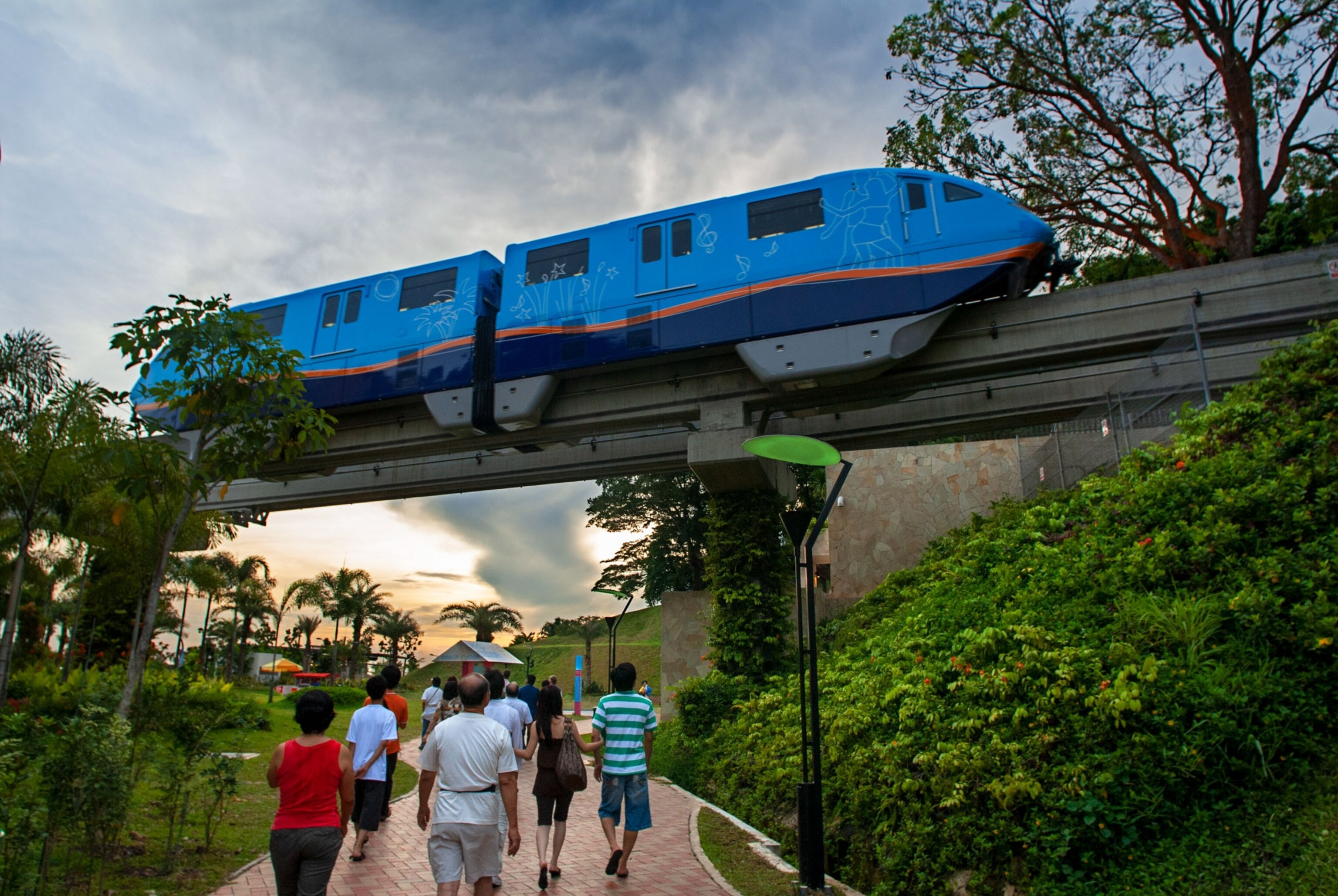 a train passes tourists on an overpass in Singapore