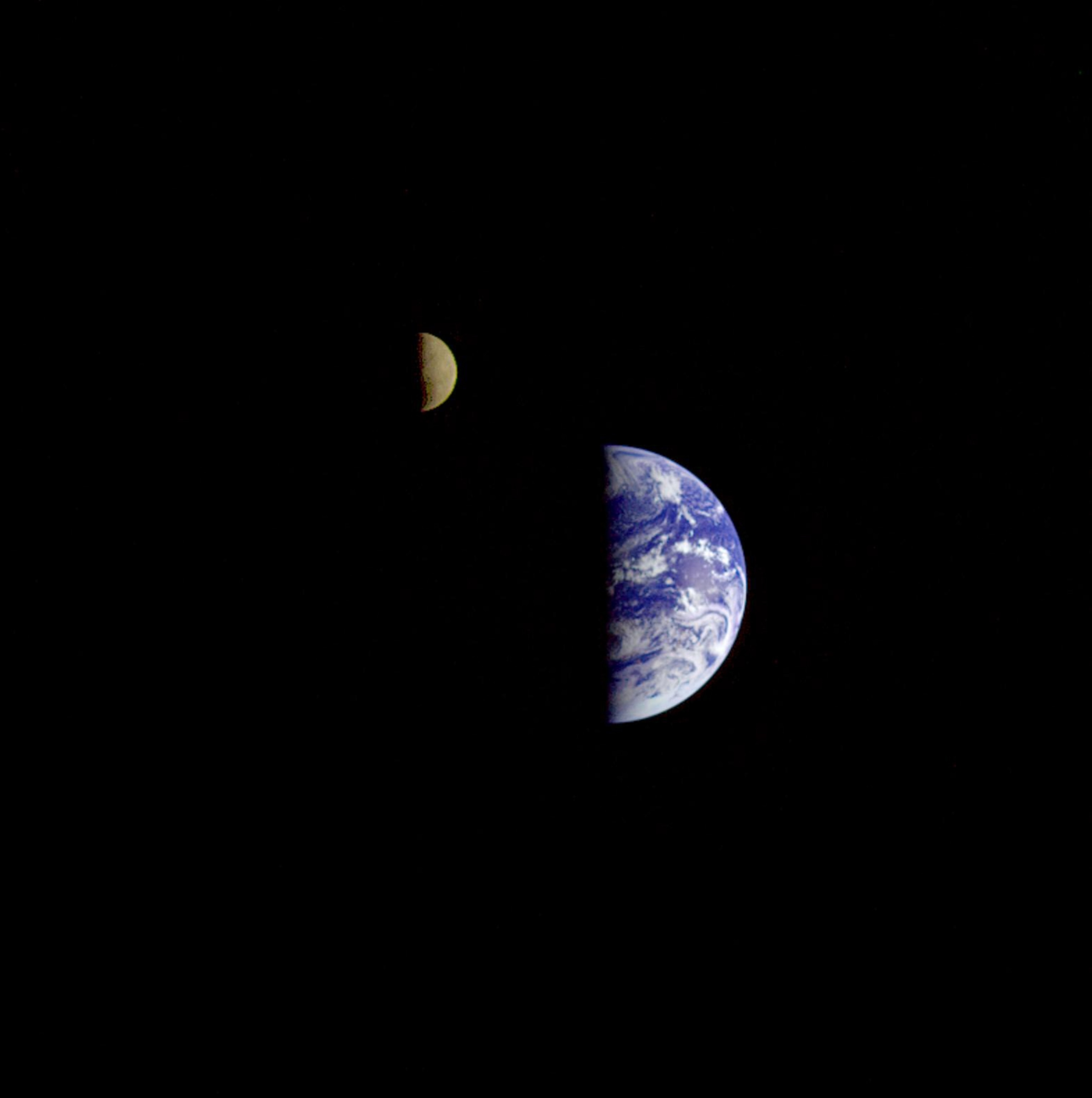 A view of the Earth and its moon, both are half illuminated by the sun and half in shadow.