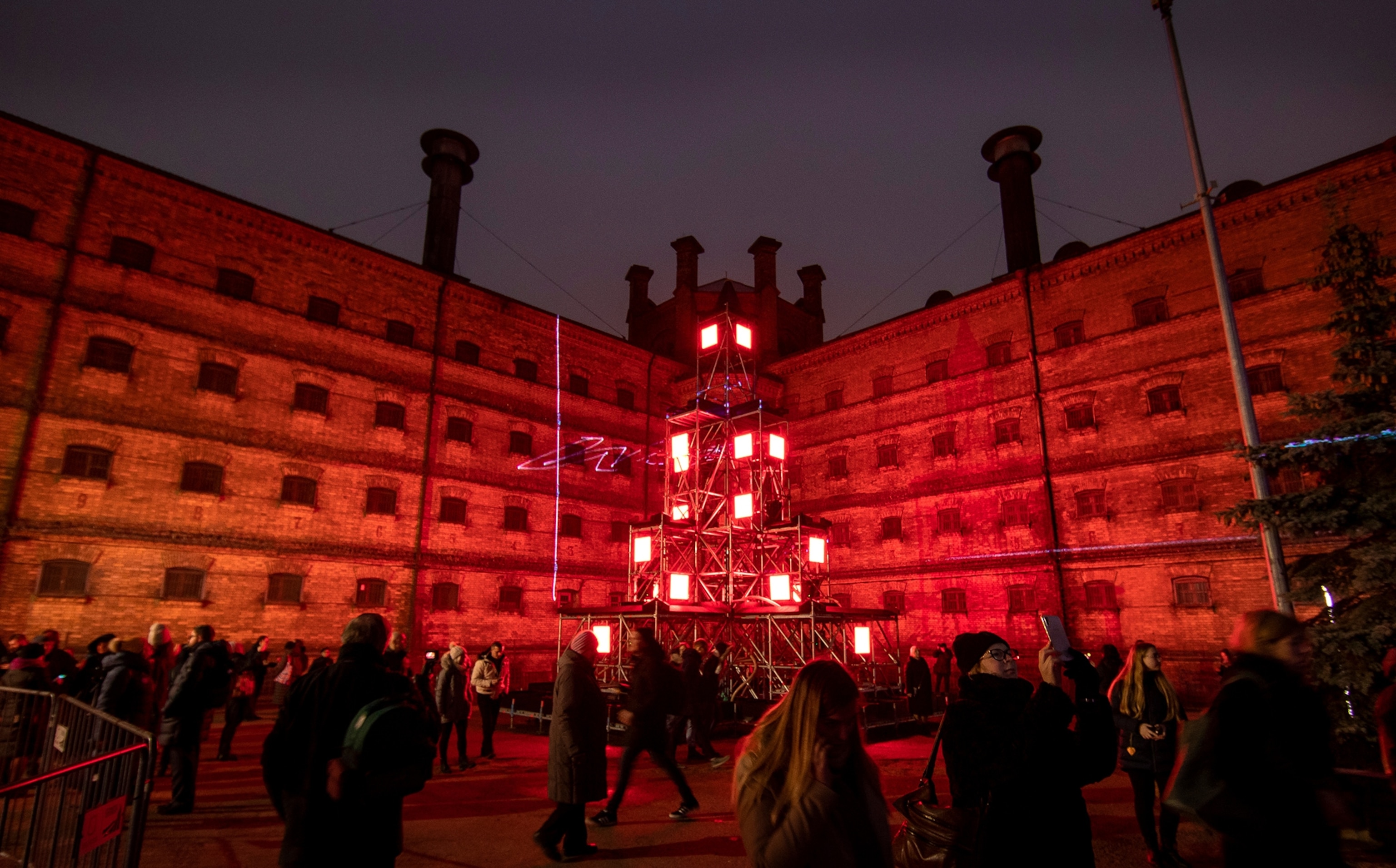 People walk by an illuminated Christmas tree during the lighting ceremony at Lukiskes prison in Vilnius, Lithuania.