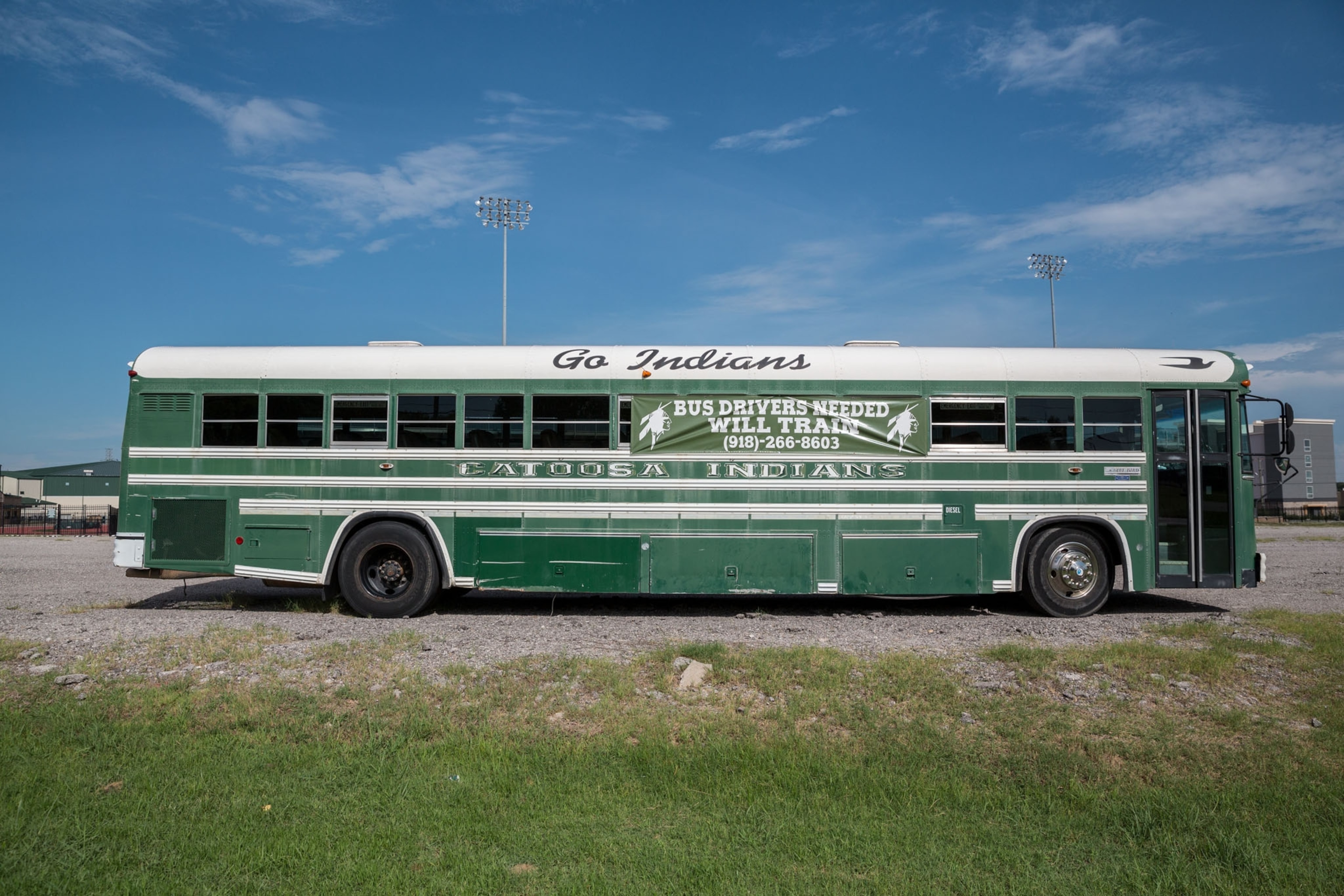 a buss painted in green color and marked with "go Indian"