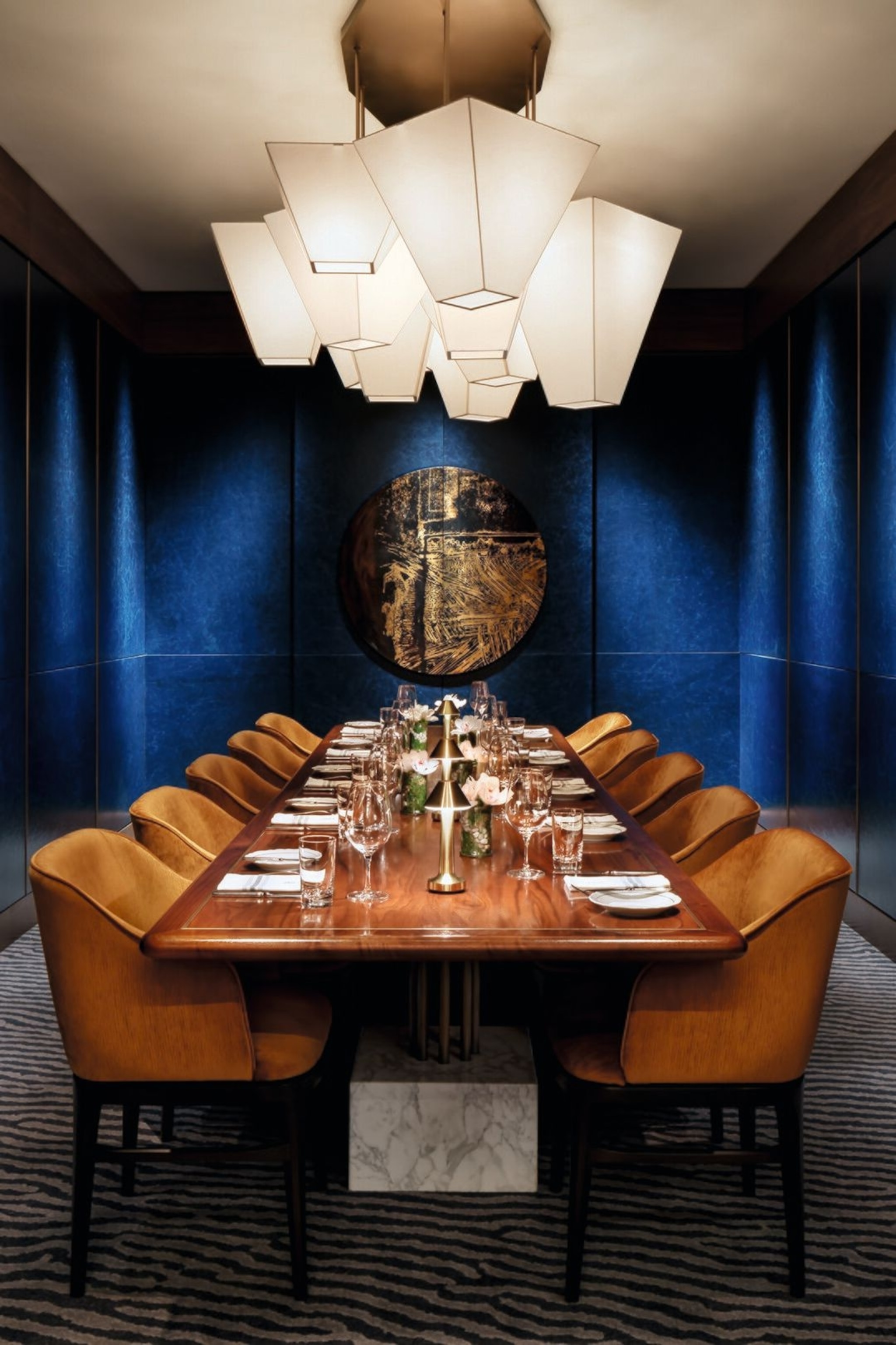 Private dining room at Fairmont Royal York. It has a large dining table and a modern light feature hanging above.
