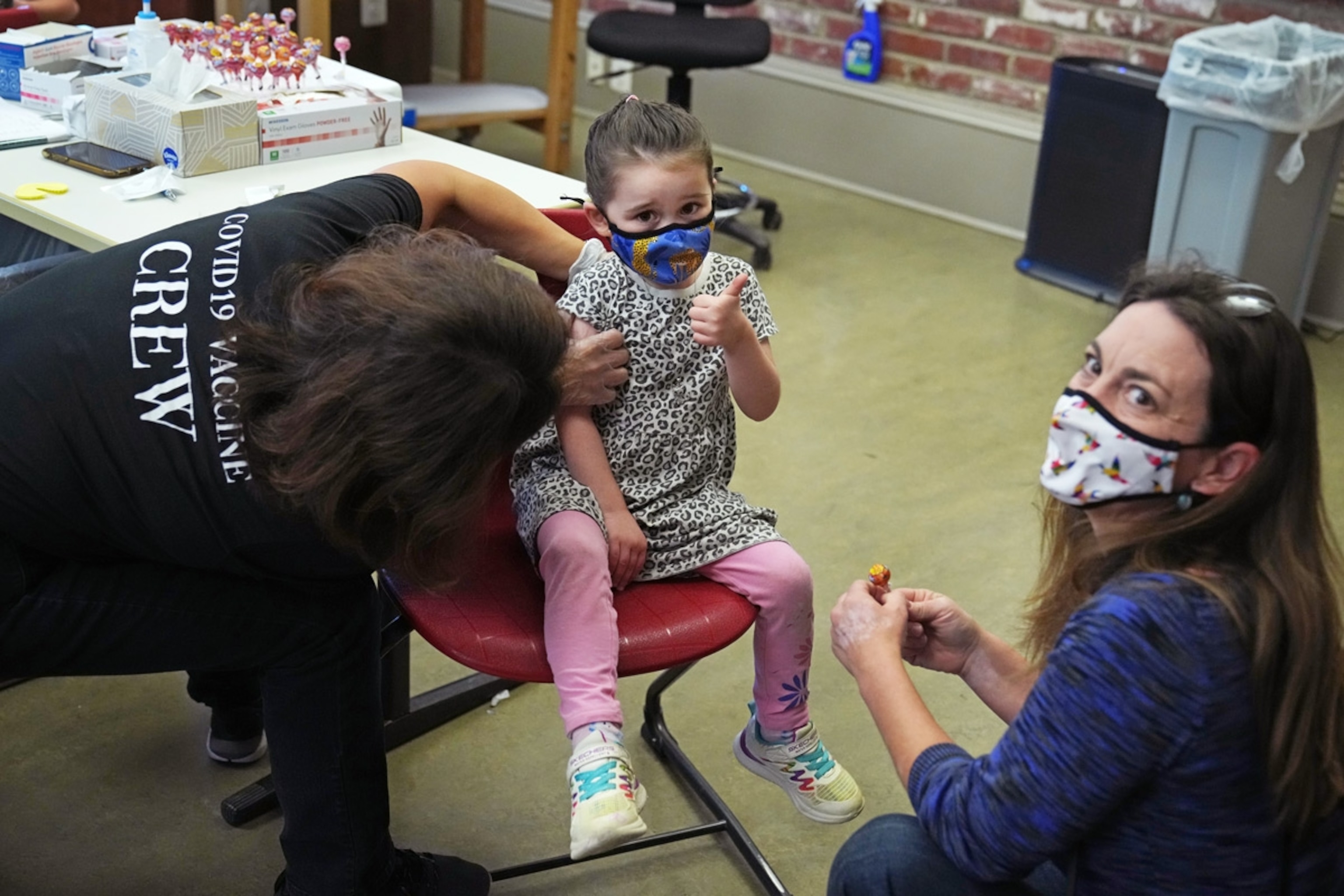 A girl receives a Pfizer-BioNTech COVID-19 vaccine from pharmacist Joan Kim, owner of Grubbs Pharmacy, at the Capitol Hill Day School in Washington, D.C., on Monday, November 8, 2021