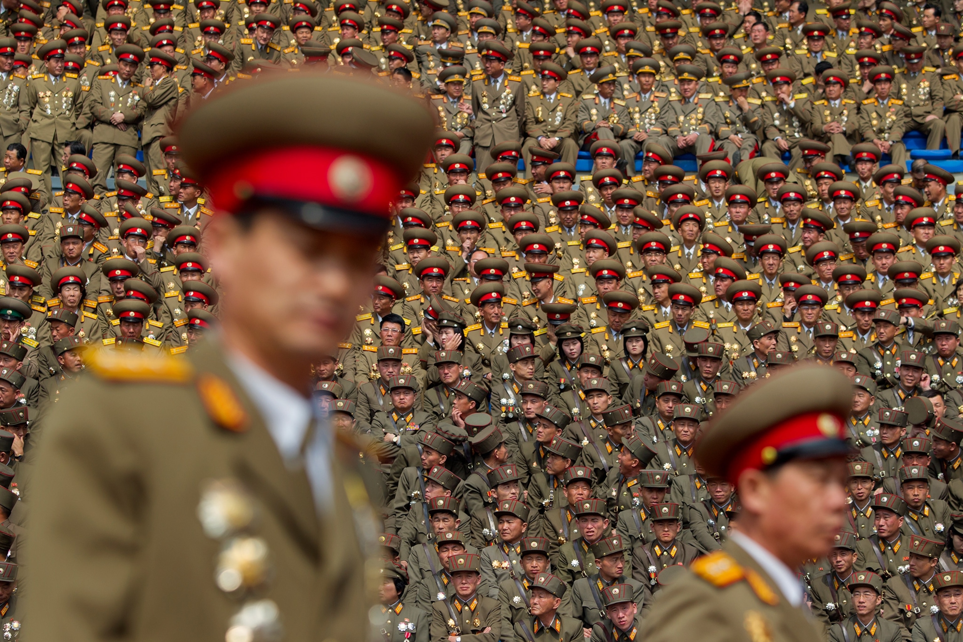 two soldiers with a stadium full of soldiers in background