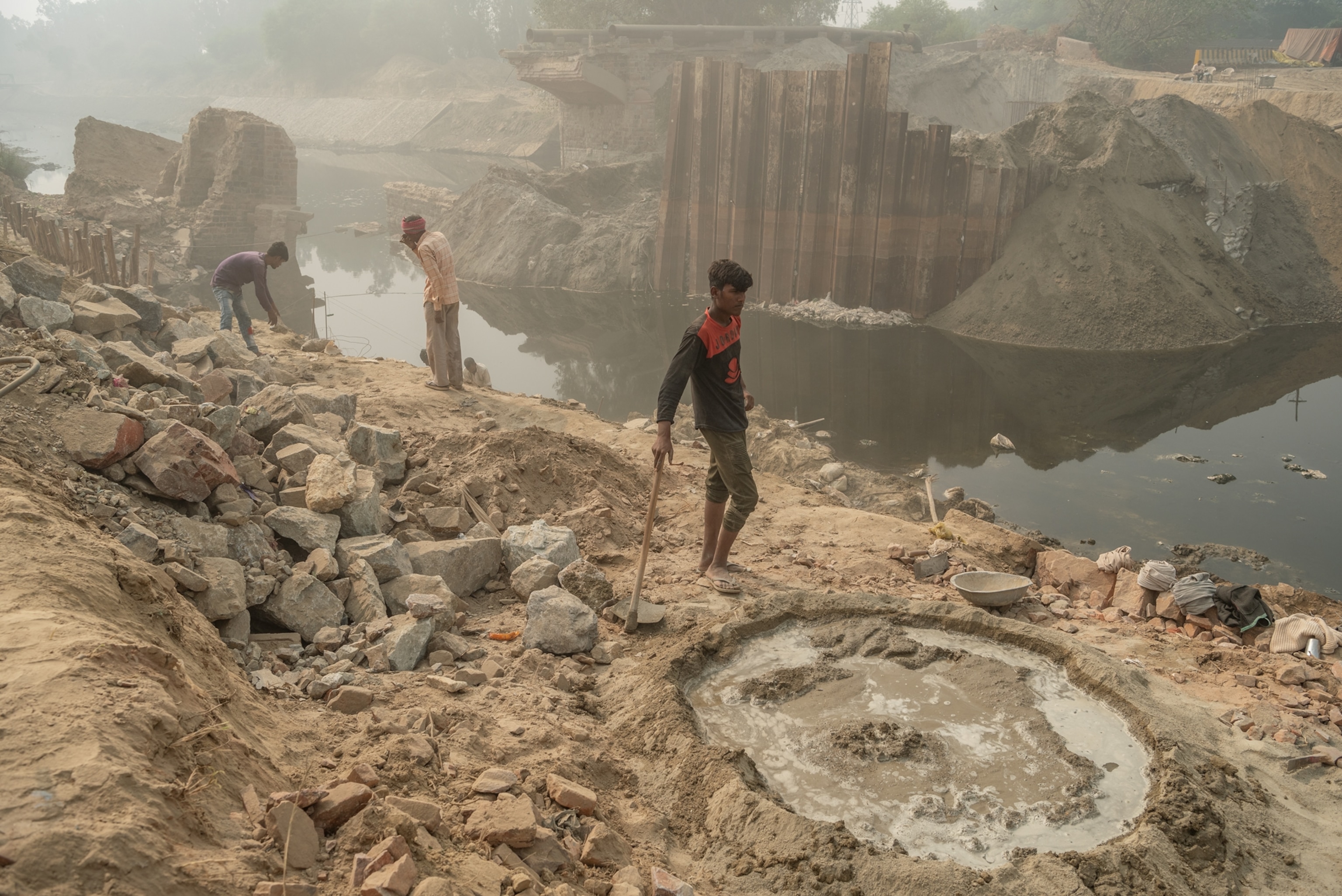 Men working on a dam in haze