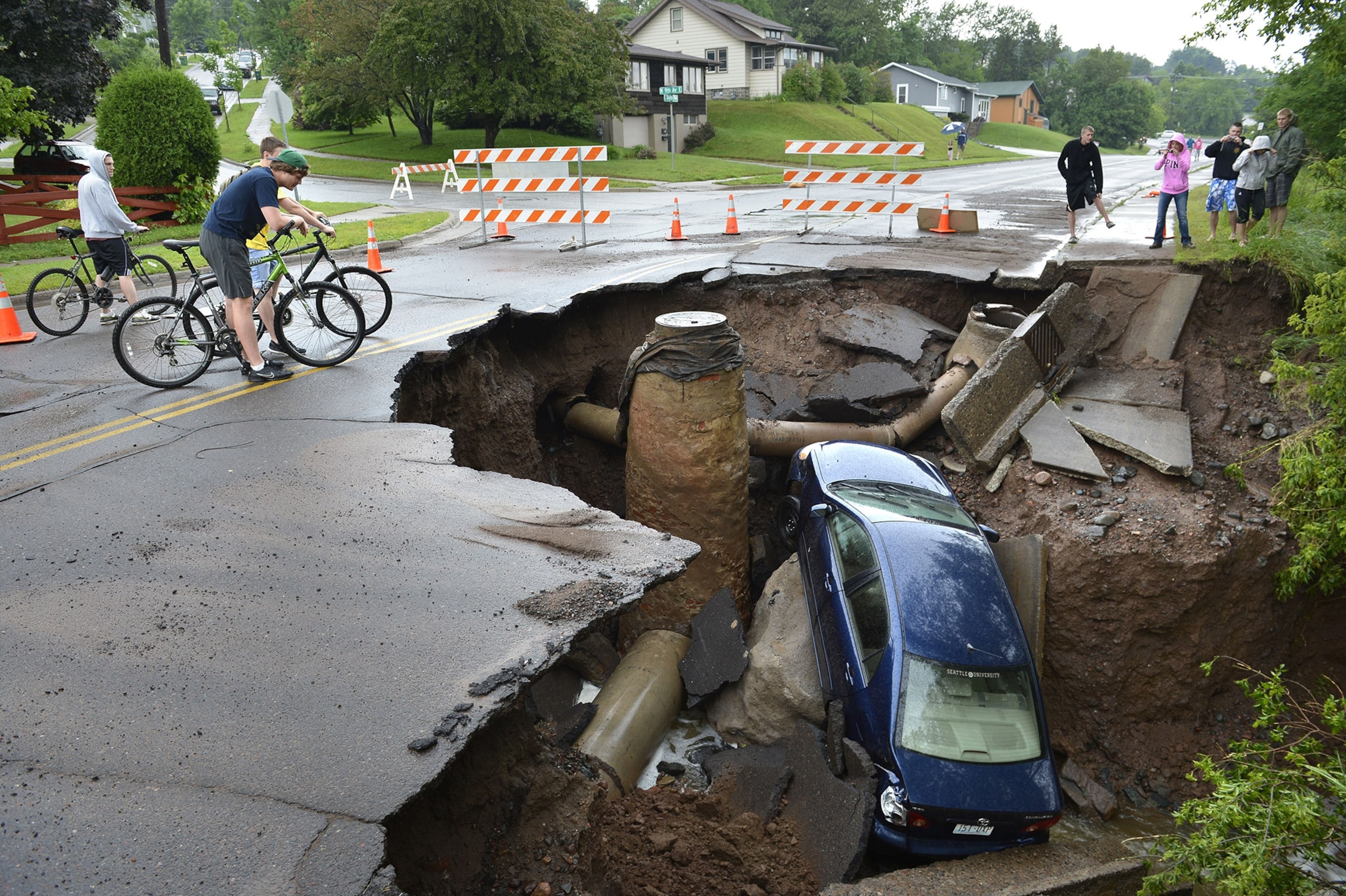Kim Russell, left, who lives nearby on Gilbralter Street and her mother Betty Box both examine the massive sinkhole that opened on Eldridge Road in Spring Hill, Fla., Saturday. T