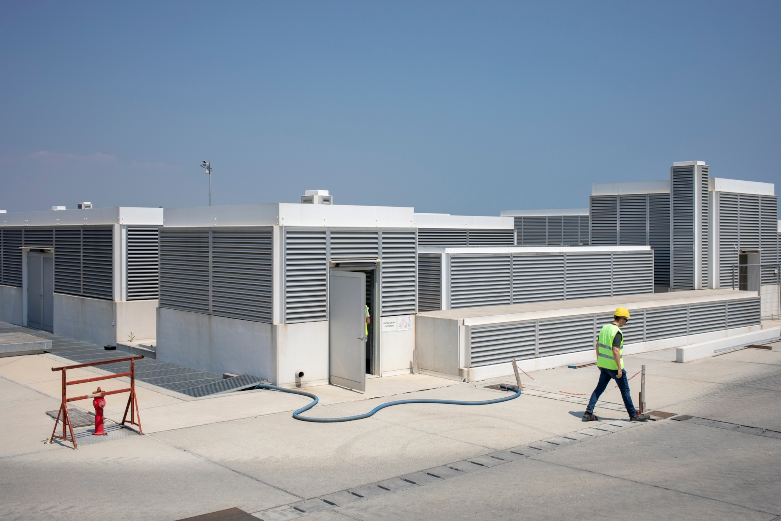 A worker walks by one building of the MO.S.E. by the Lido's lagoon gate.