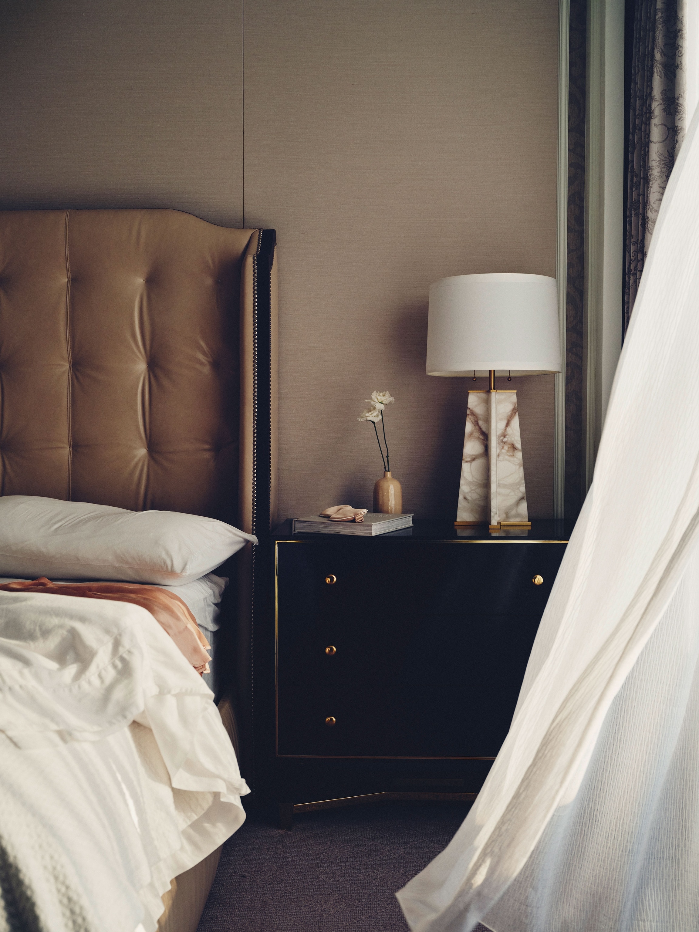 interior of guest room where curtain blows in with the wind