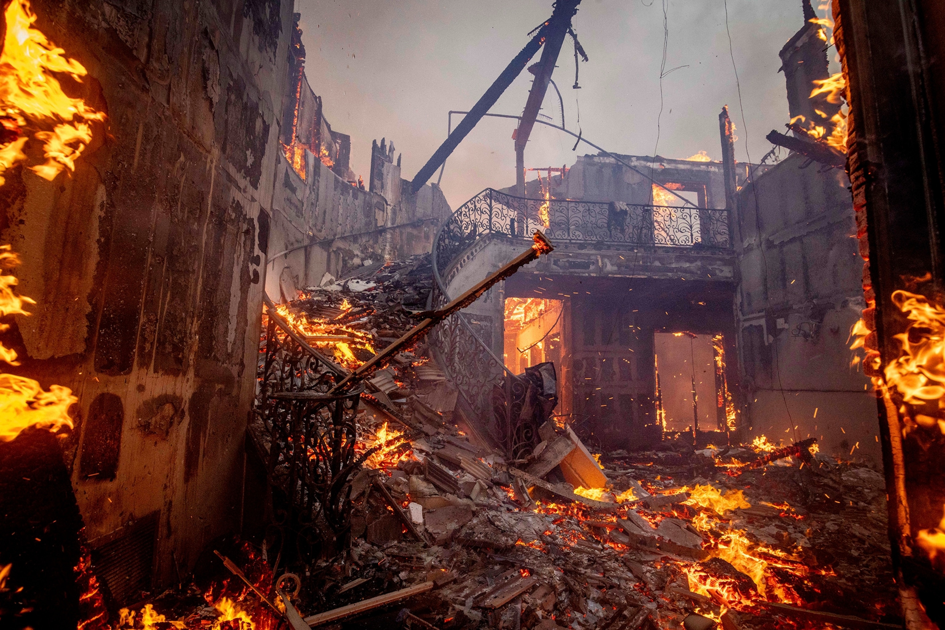 Water is dropped by helicopter on the advancing Palisades Fire in the Pacific Palisades neighborhood of Los Angeles, Tuesday, Jan. 7, 2025.