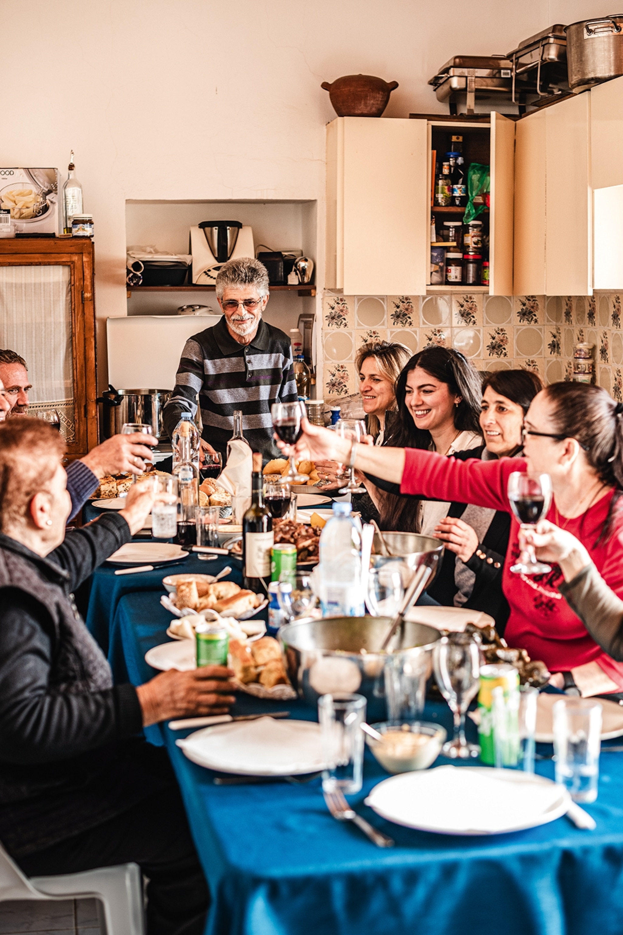 Family sat round a dinner table with food and wine laid out in front of them