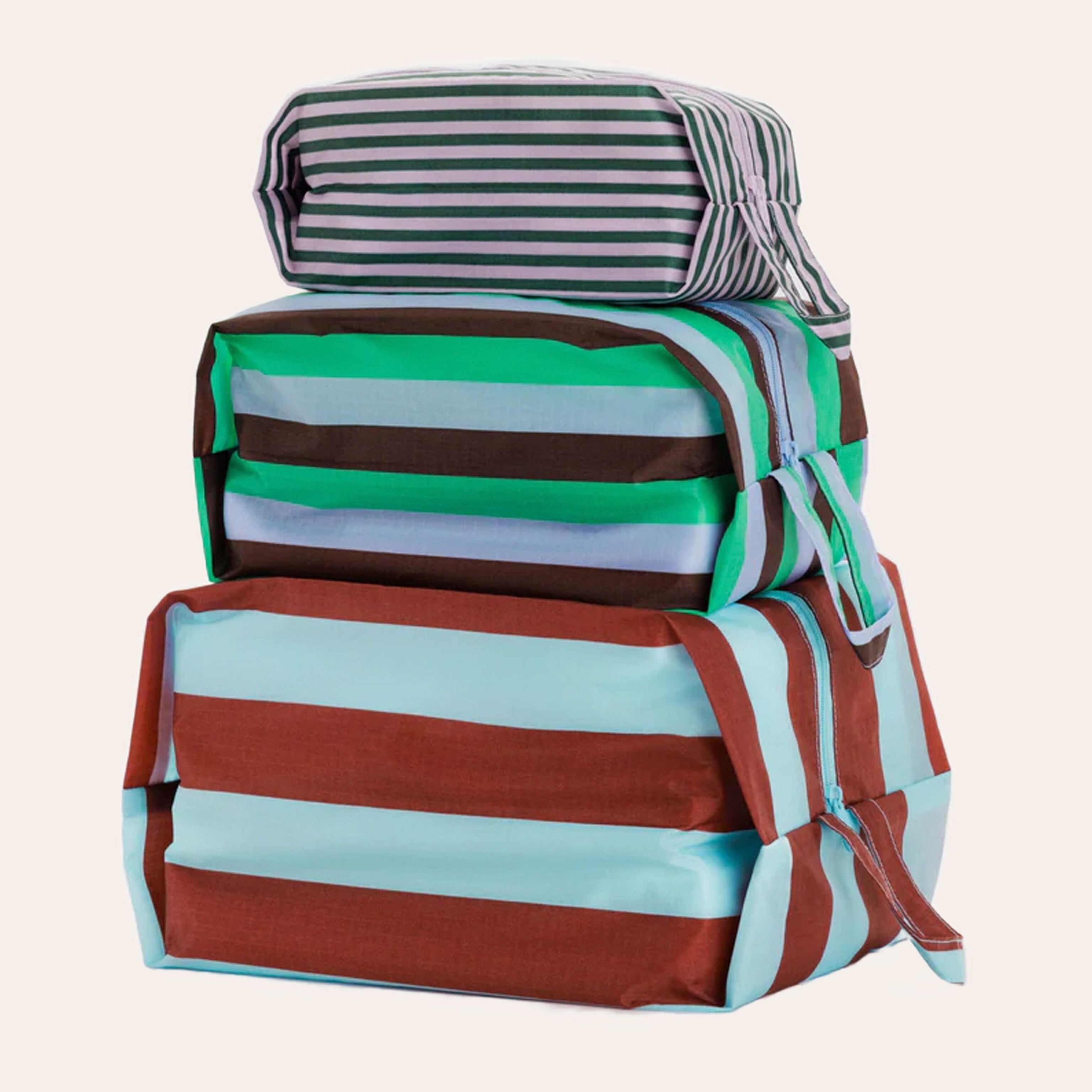 Three striped nylon travel zip bags, the small is pink and green, the medium is blue, green, and maroon, and the large is blue and red.