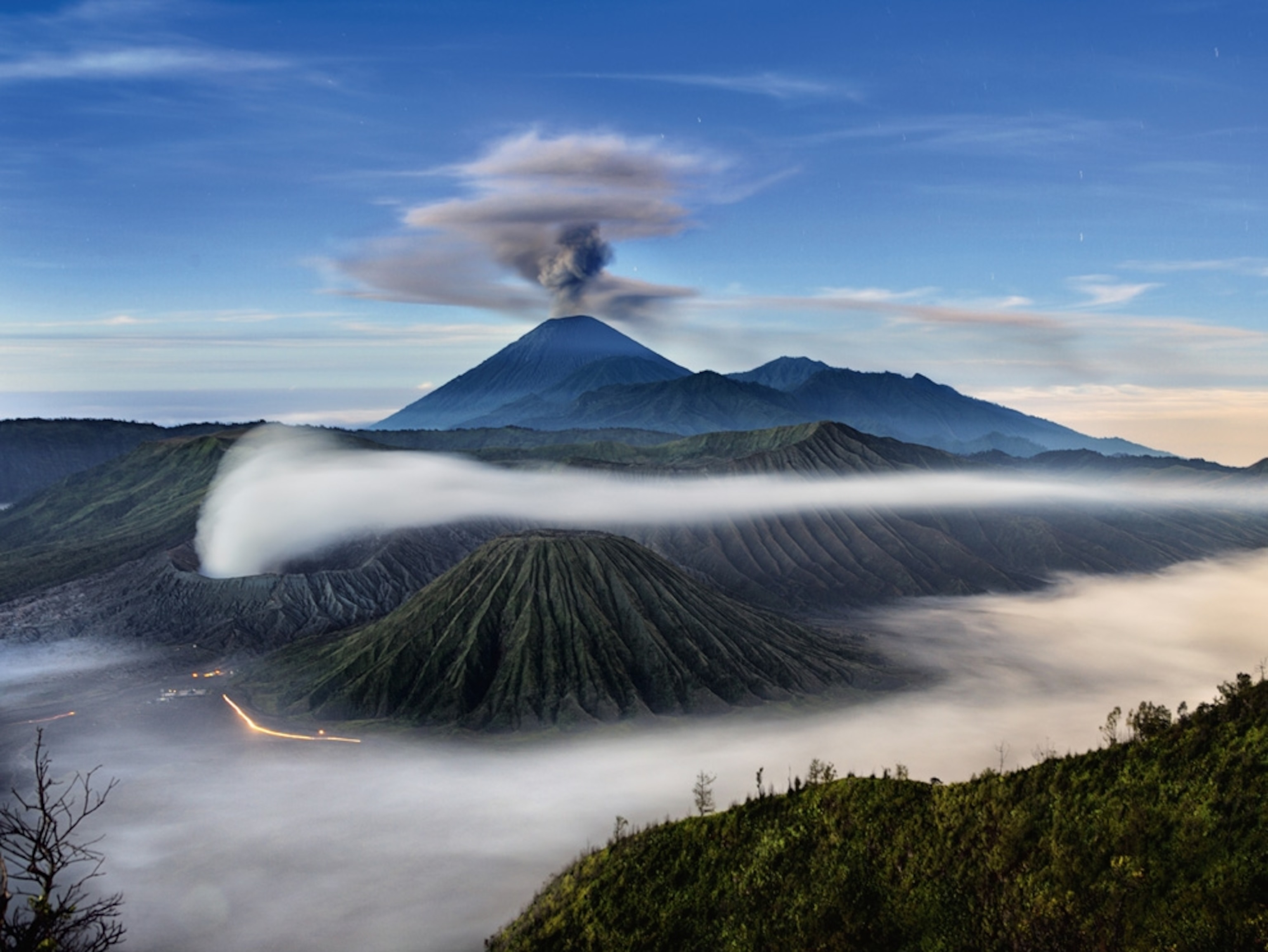 Wisps of clouds around three volcanoes
