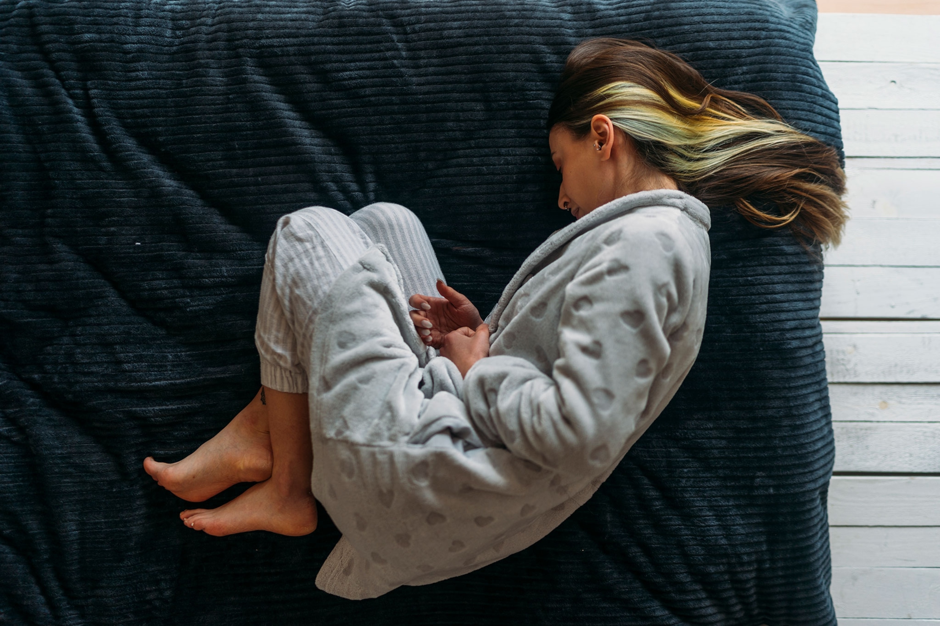 Woman scrunched up in bed