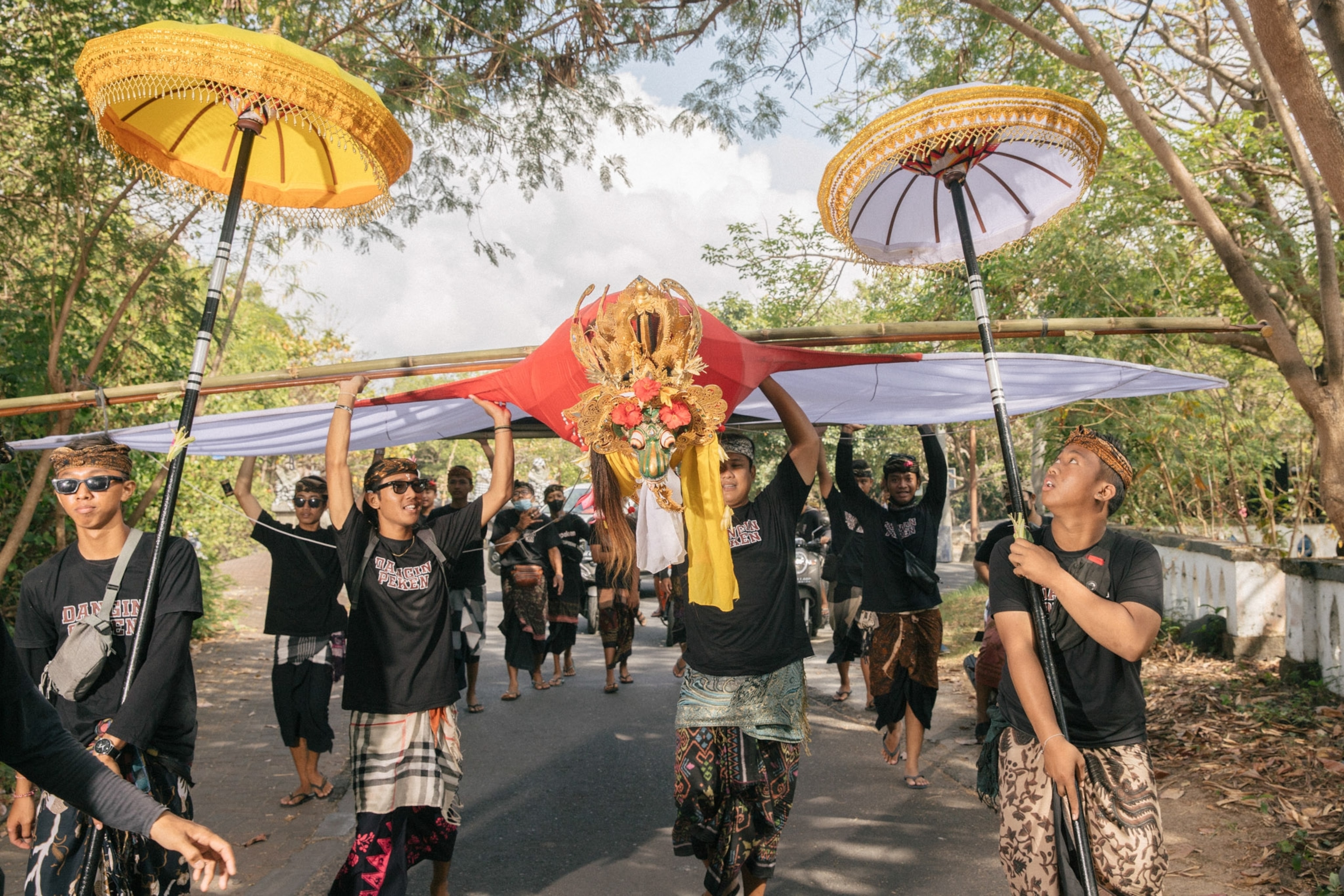 Youth members of the Dangin Peken hamlet walk with the sacred janggan kite