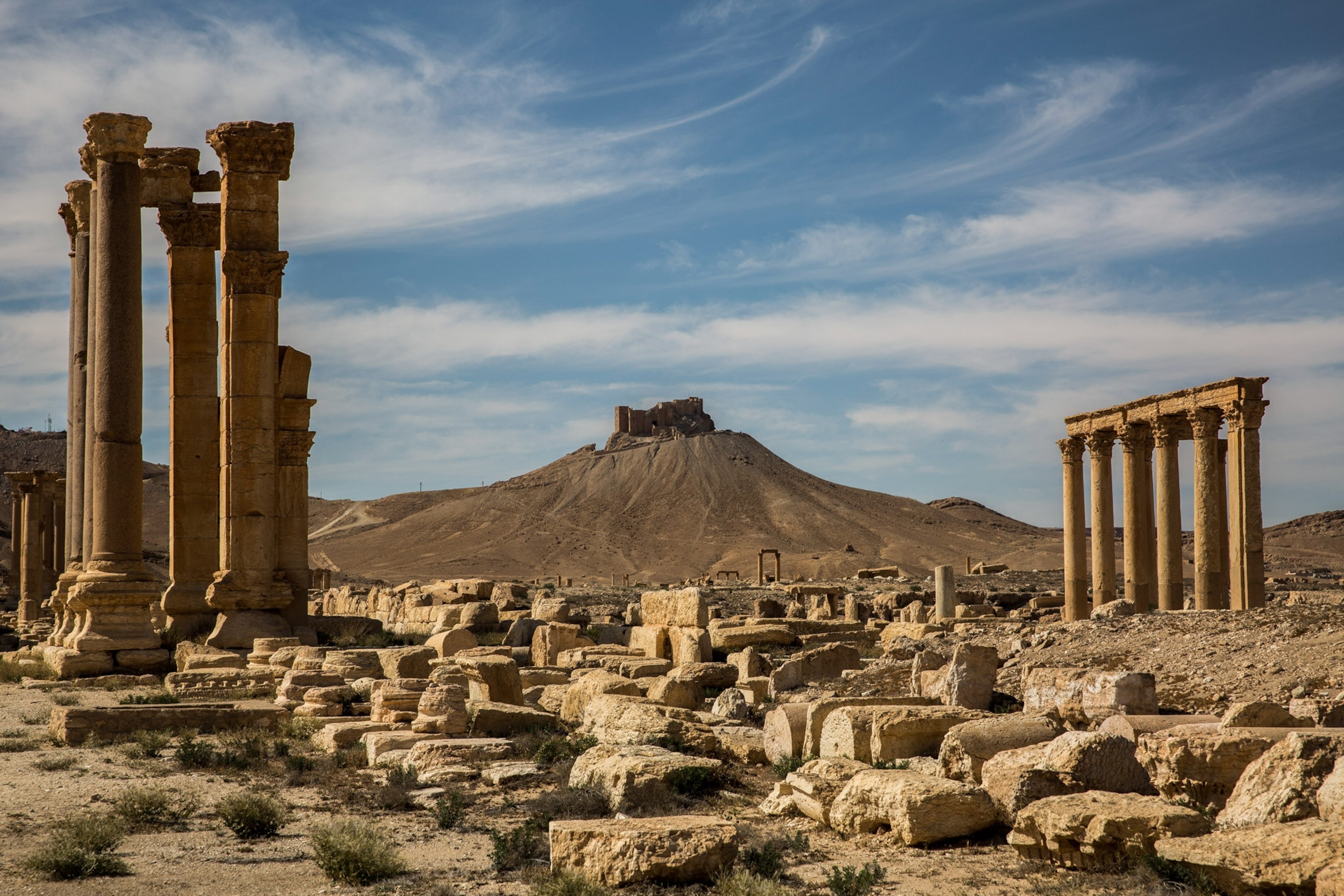 Under blue sky you see the remains of the ruins and the citadel in the distance.