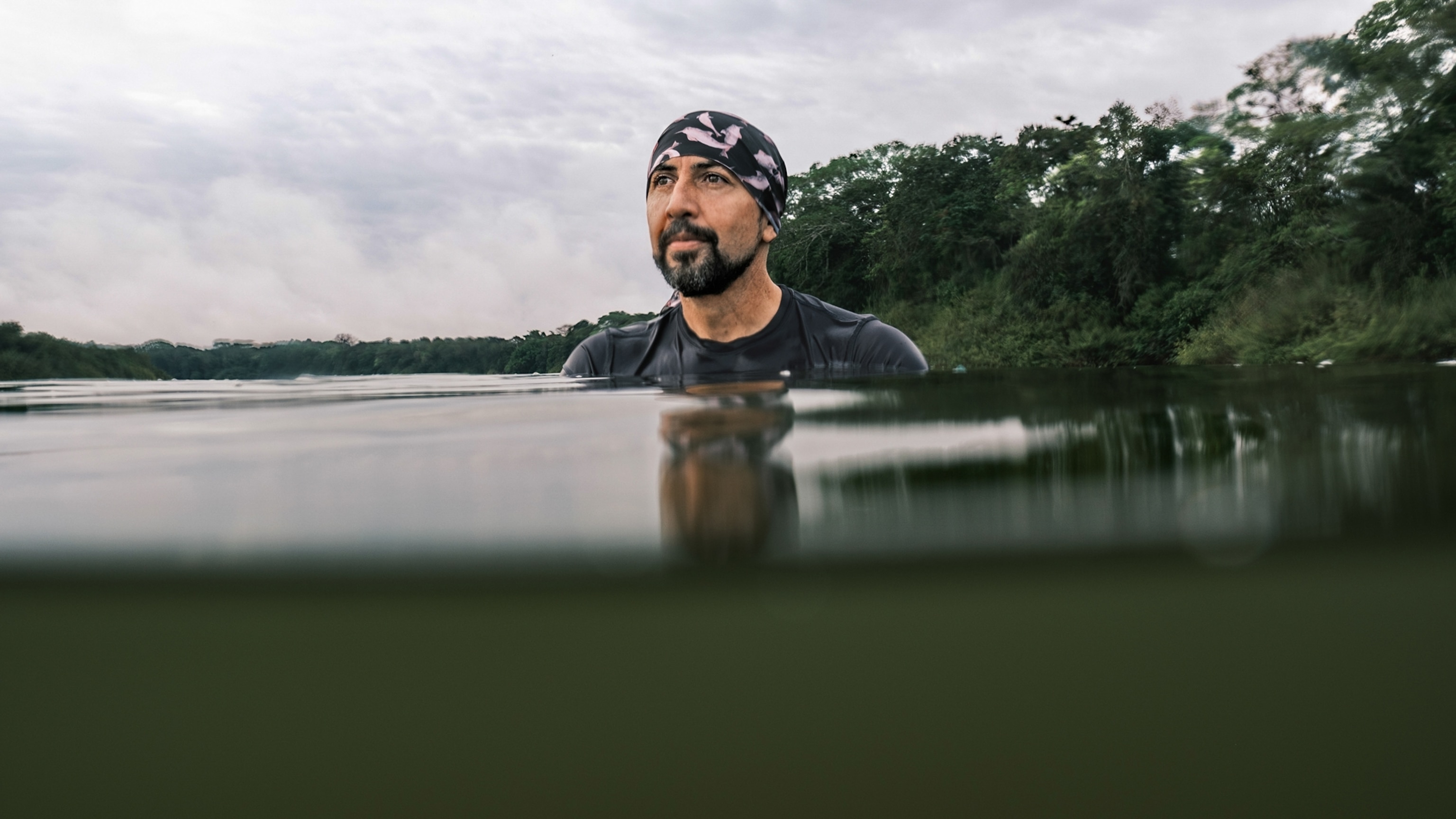 Man in kerchief in the water up to his shoulders.