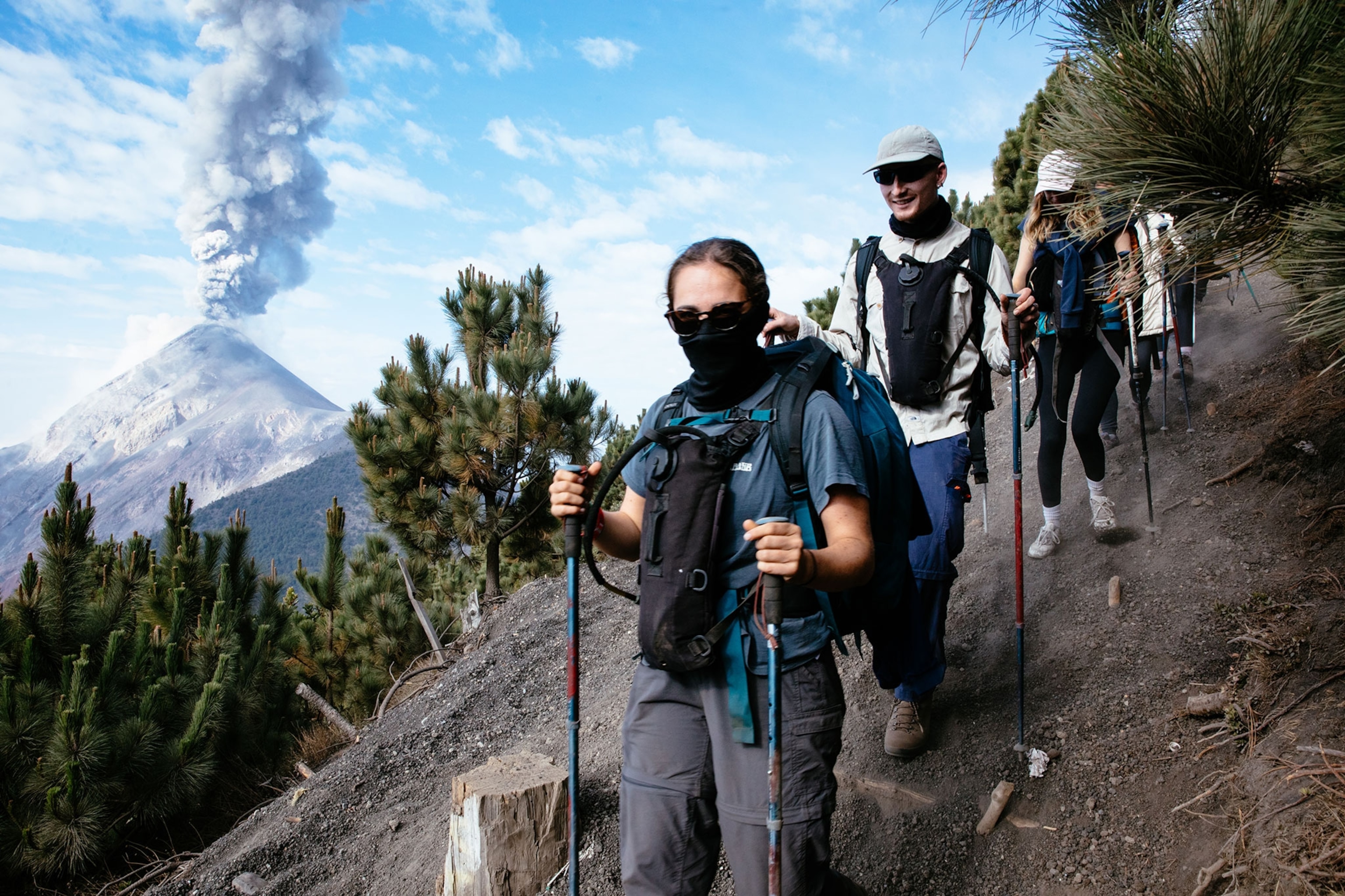 Hikers on Acatenango while Volcán de Fuego erupts in the background