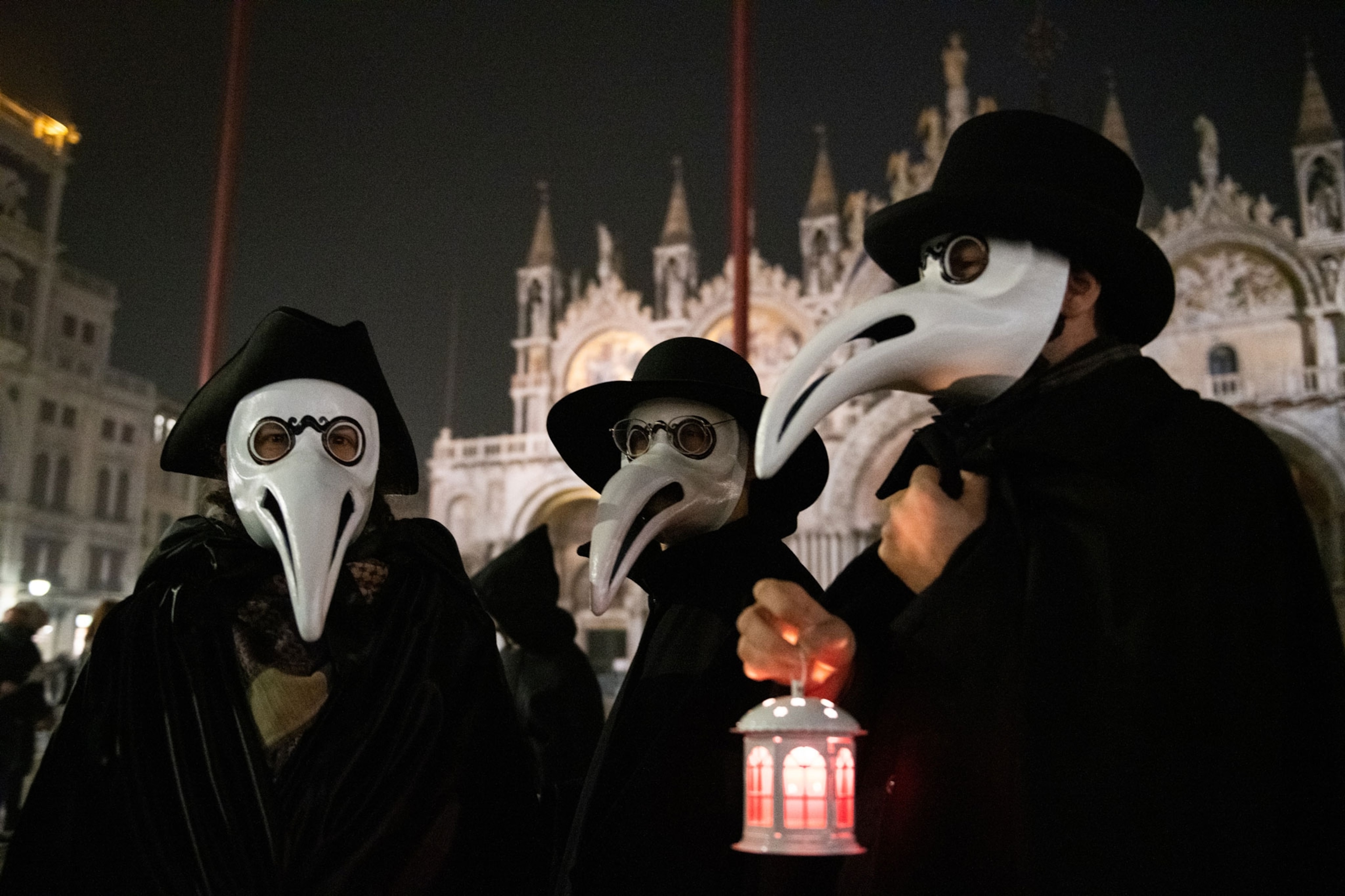 three people wearing plague doctor masks