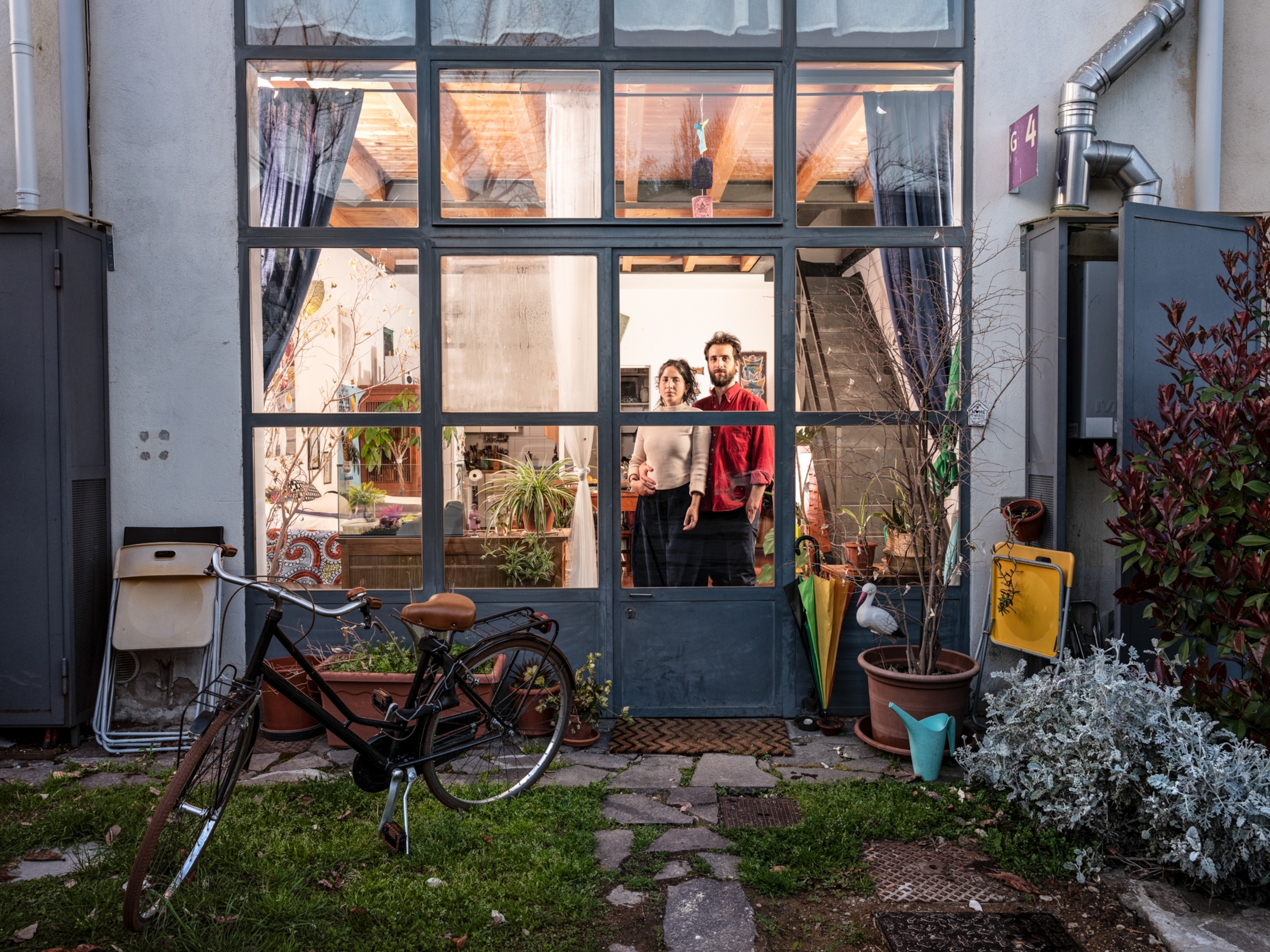 a couple poses for a portrait taken through their window in Italy