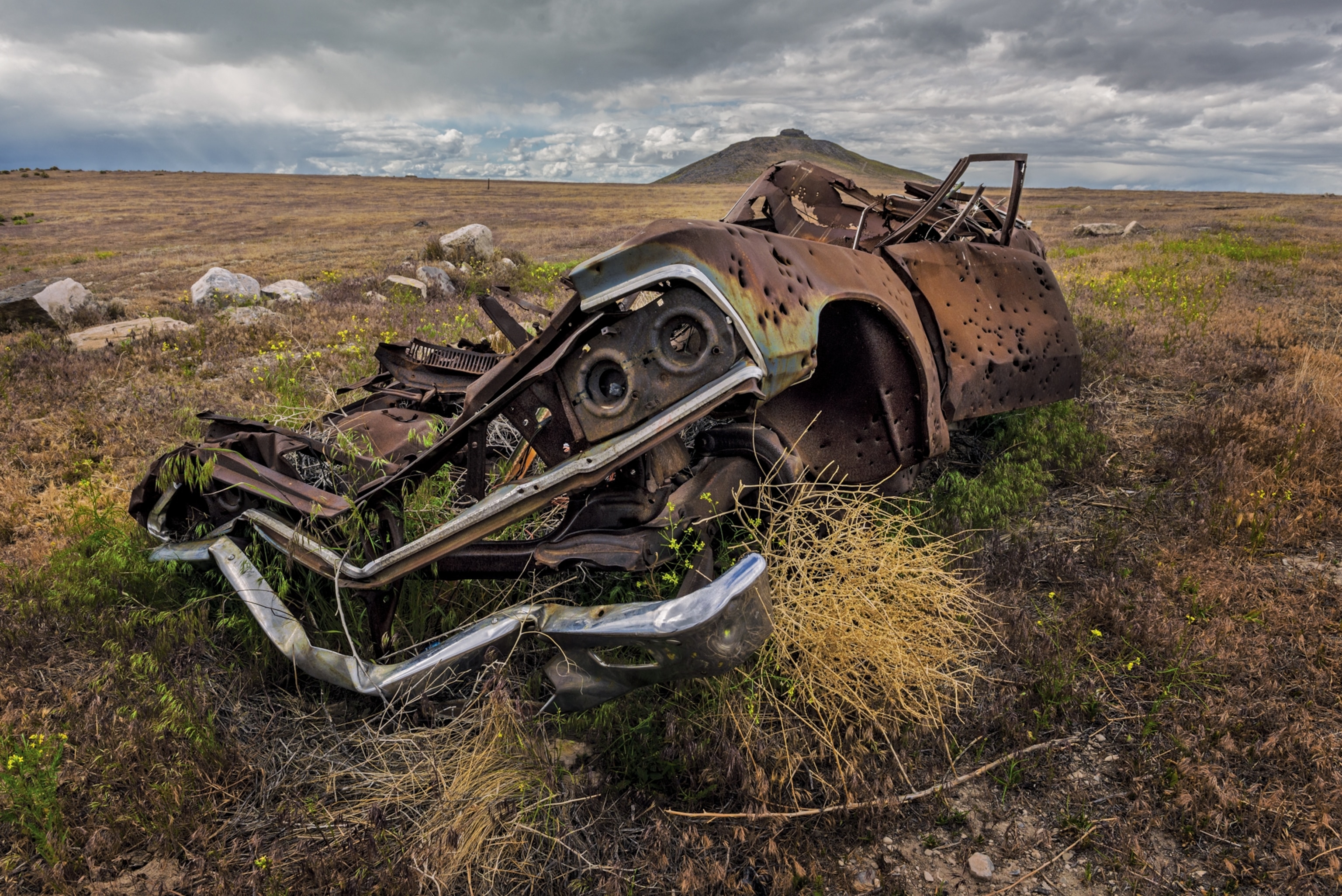 an abandoned car acting as a tumbleweed barrier