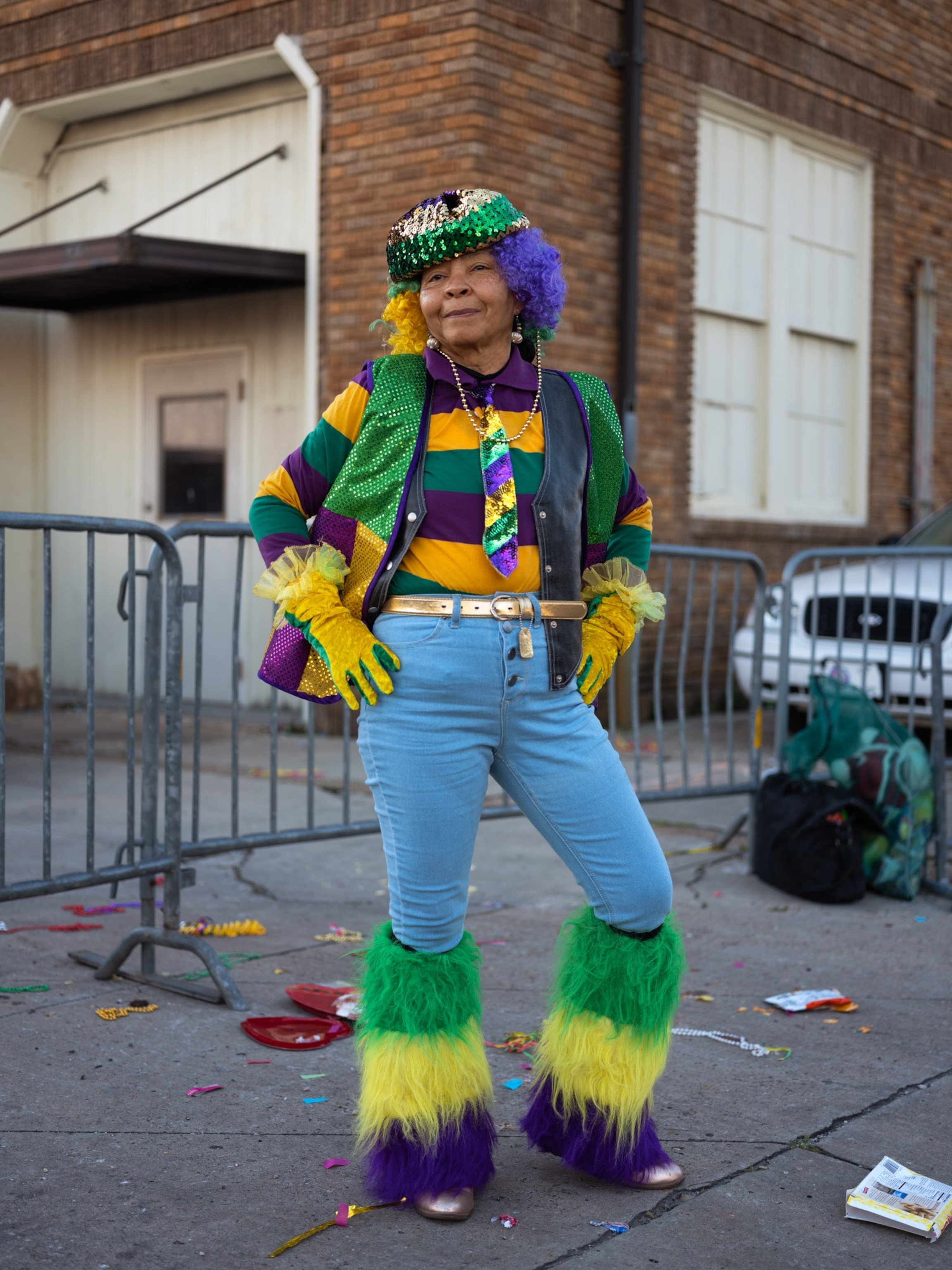 a woman posing with a striped outfit - green, yellow and purple for Mardi Gras.