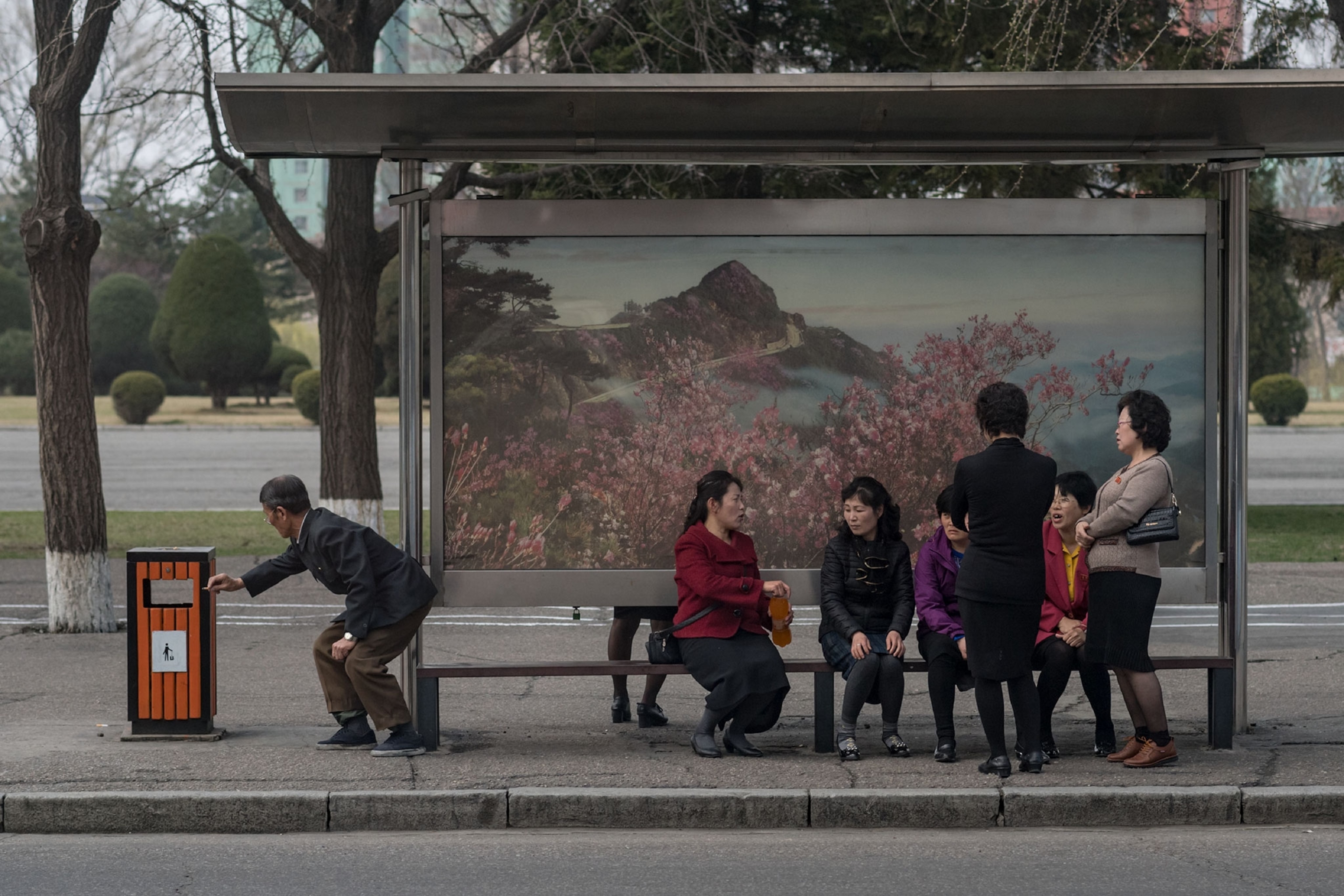 people waiting at a bus stop in North Korea