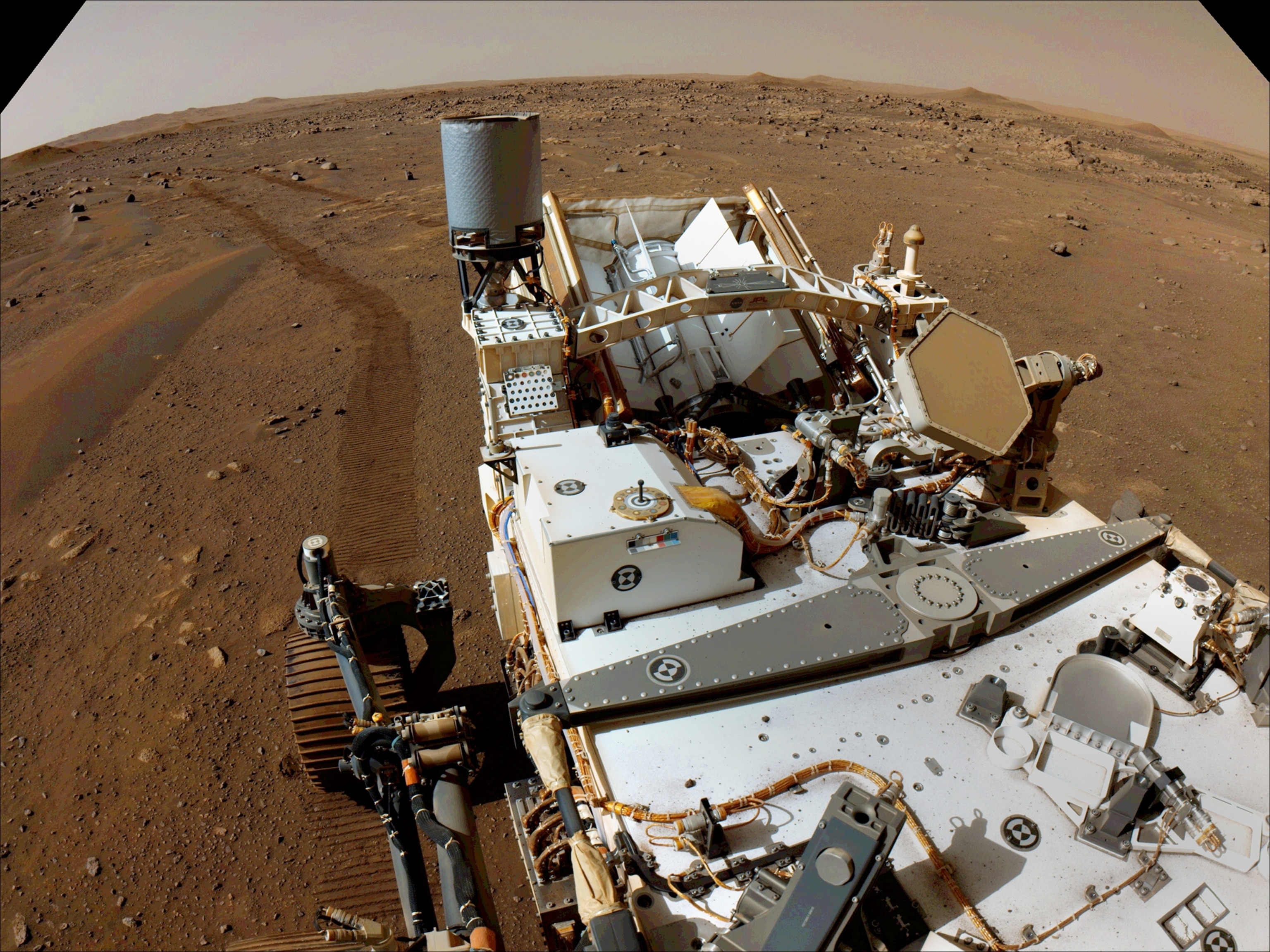 Picture of tracks from wide wheel on brown surface.