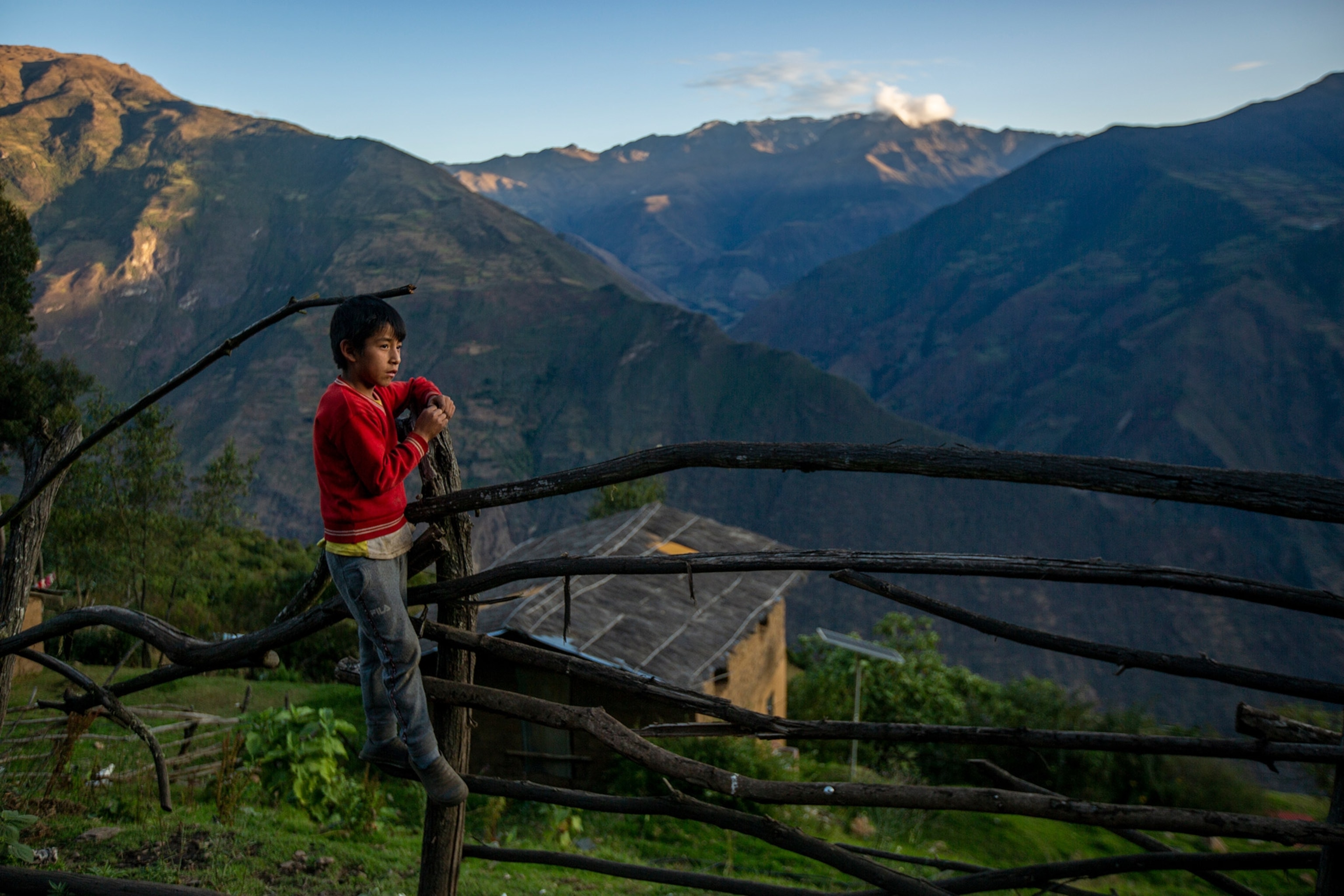 Yain Tapia, son of Elisabeth Vargas looks at the mountains that surround the community of Marampata located in the Cusco region