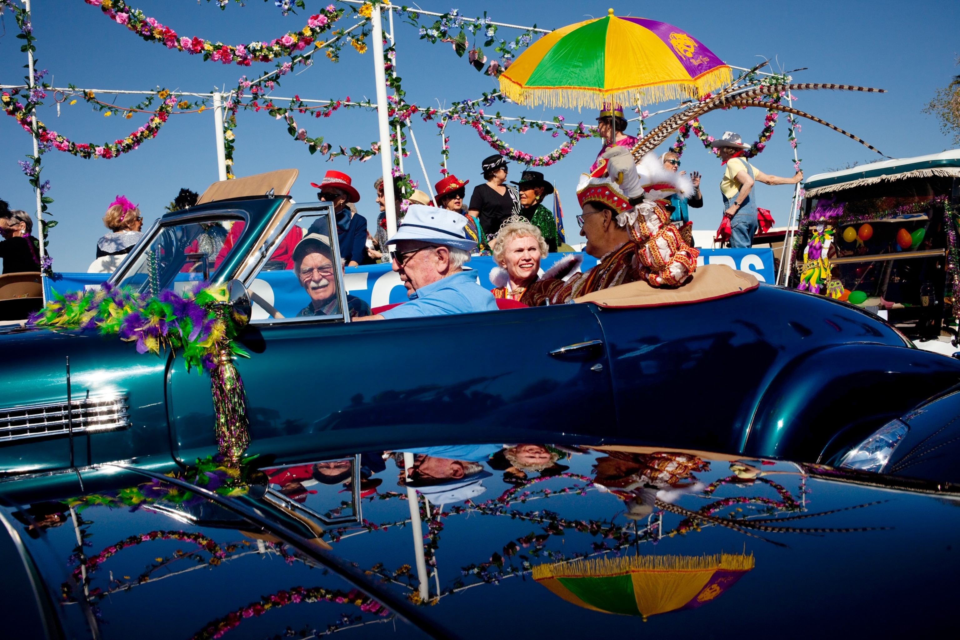 Picture of dressed up people in decorated convertibles.