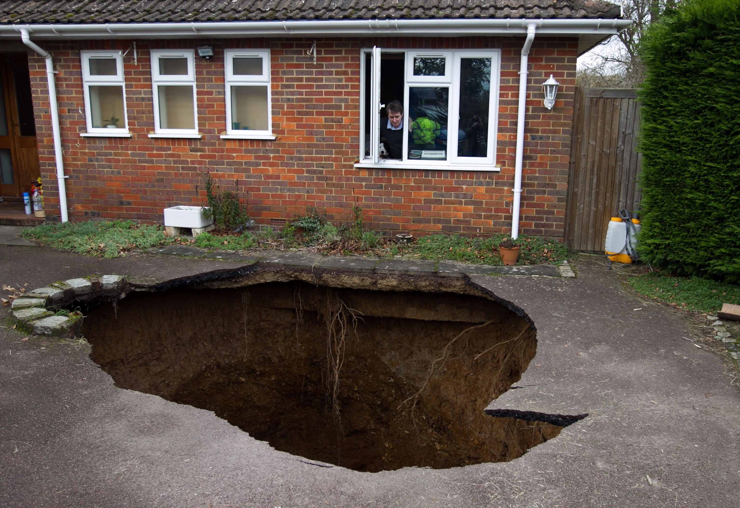 Kim Russell, left, who lives nearby on Gilbralter Street and her mother Betty Box both examine the massive sinkhole that opened on Eldridge Road in Spring Hill, Fla., Saturday. T
