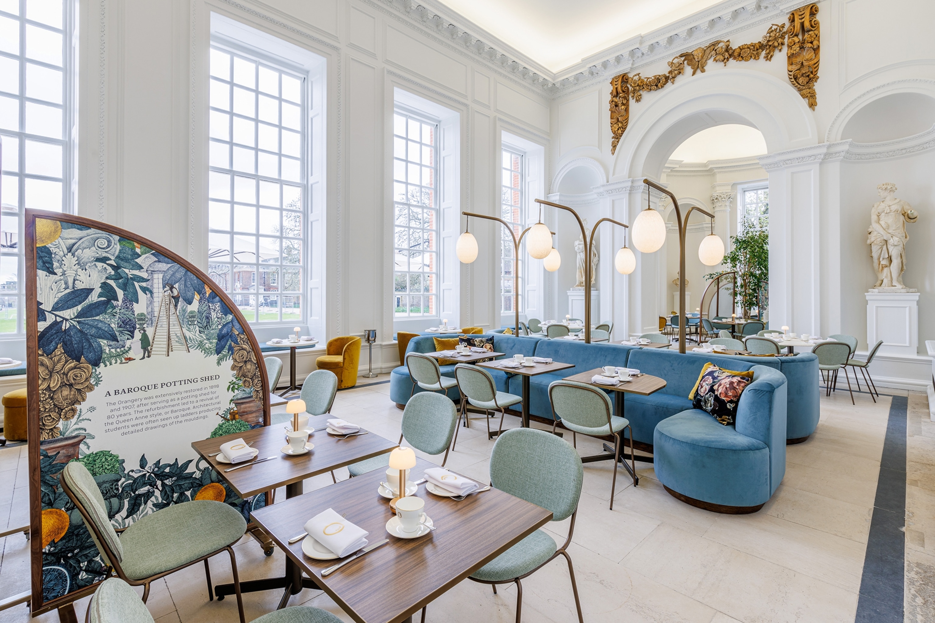 Grand tearoom with large windows, high ceilings and green furnishings