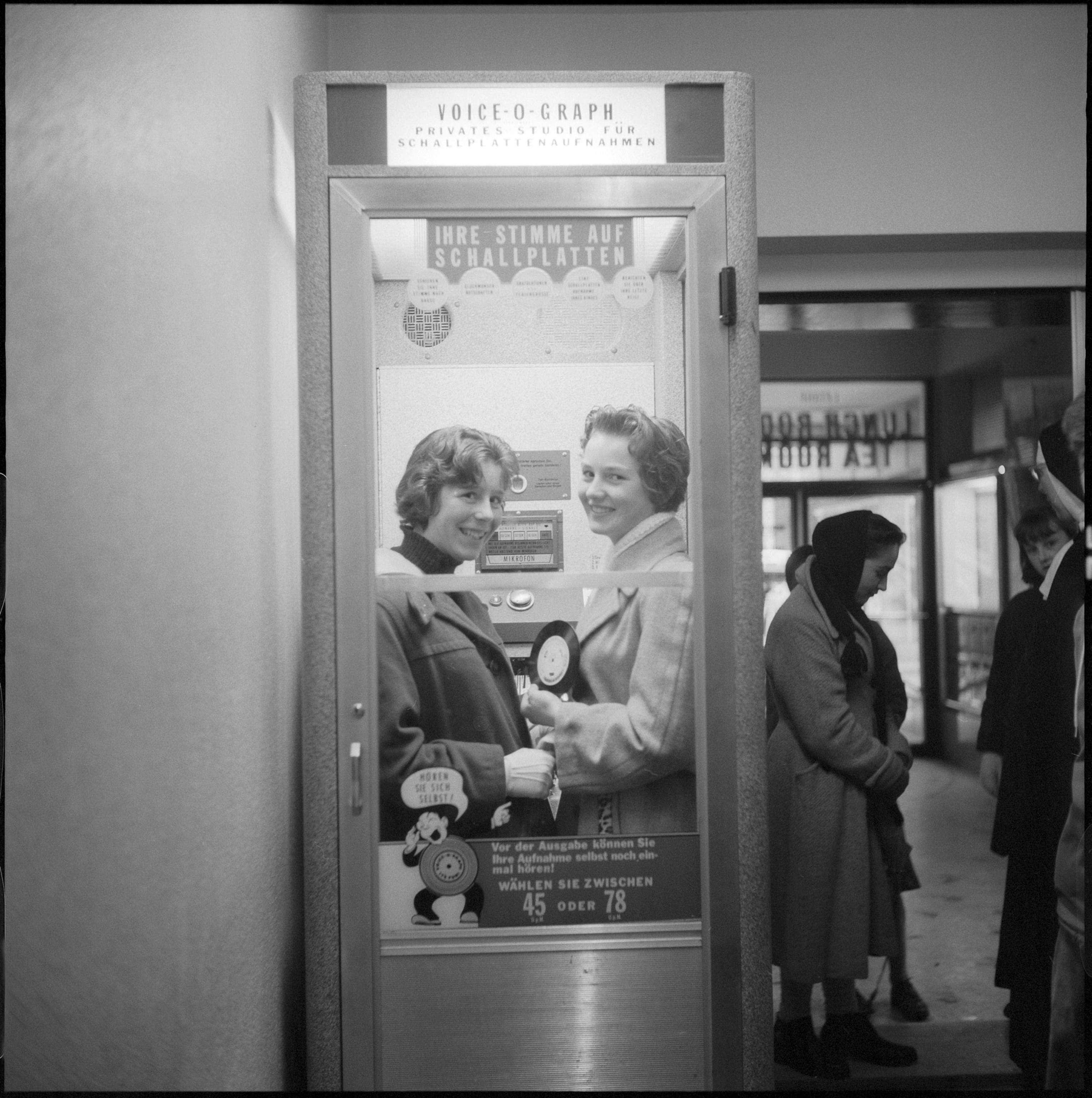 Photo of two women in recording booth holding record