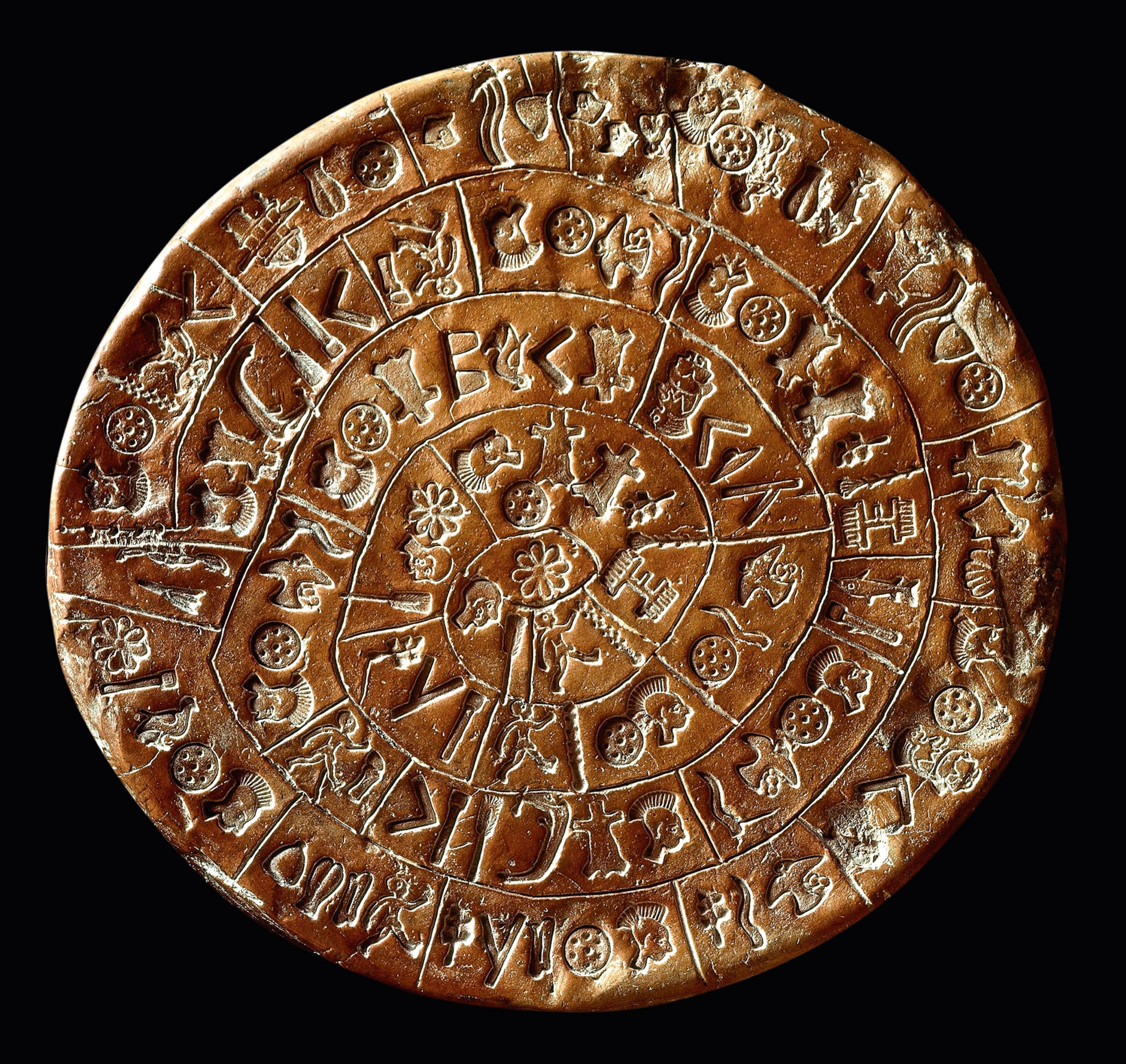 A brown clay disk with glyphs inscribed