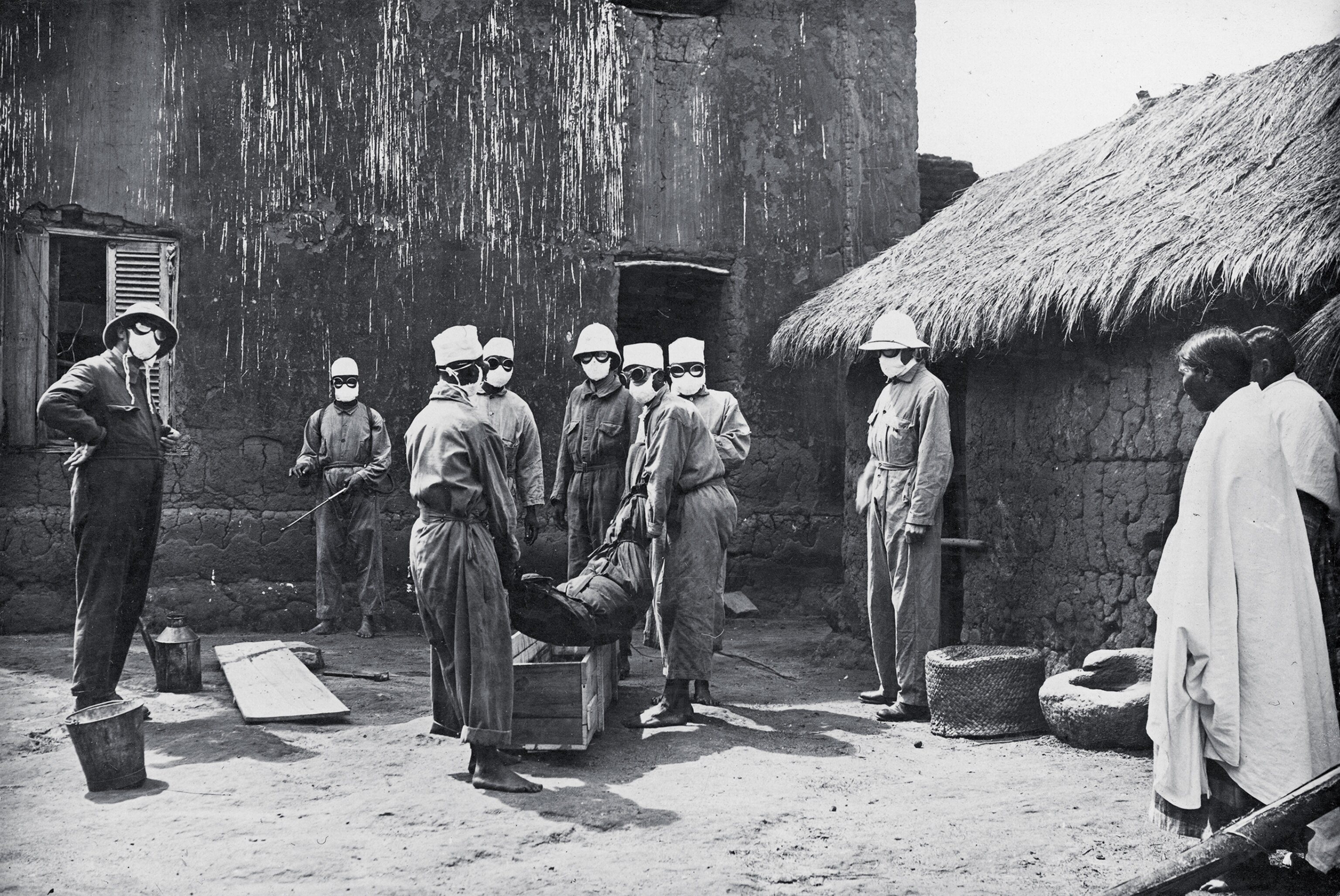 black and white historical photo people handling a dead body.