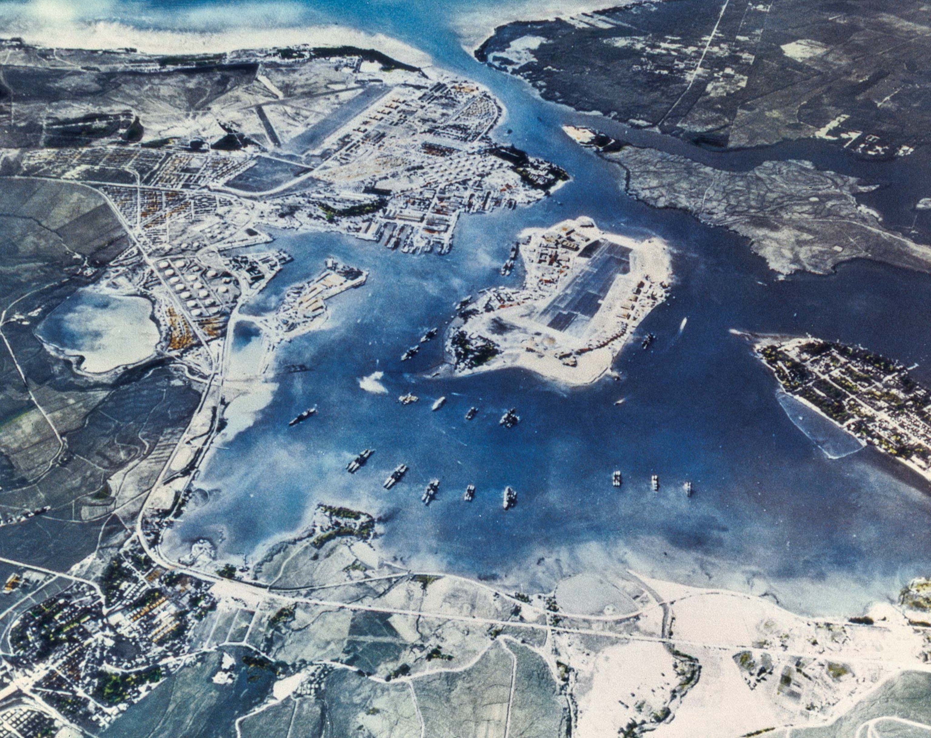 Aerial view of Pearl Harbor naval base on Honolulu, Oahu, Hawaii. Ford Island is in the center, with the navy yard beyond it and Hickam Field in the upper left.