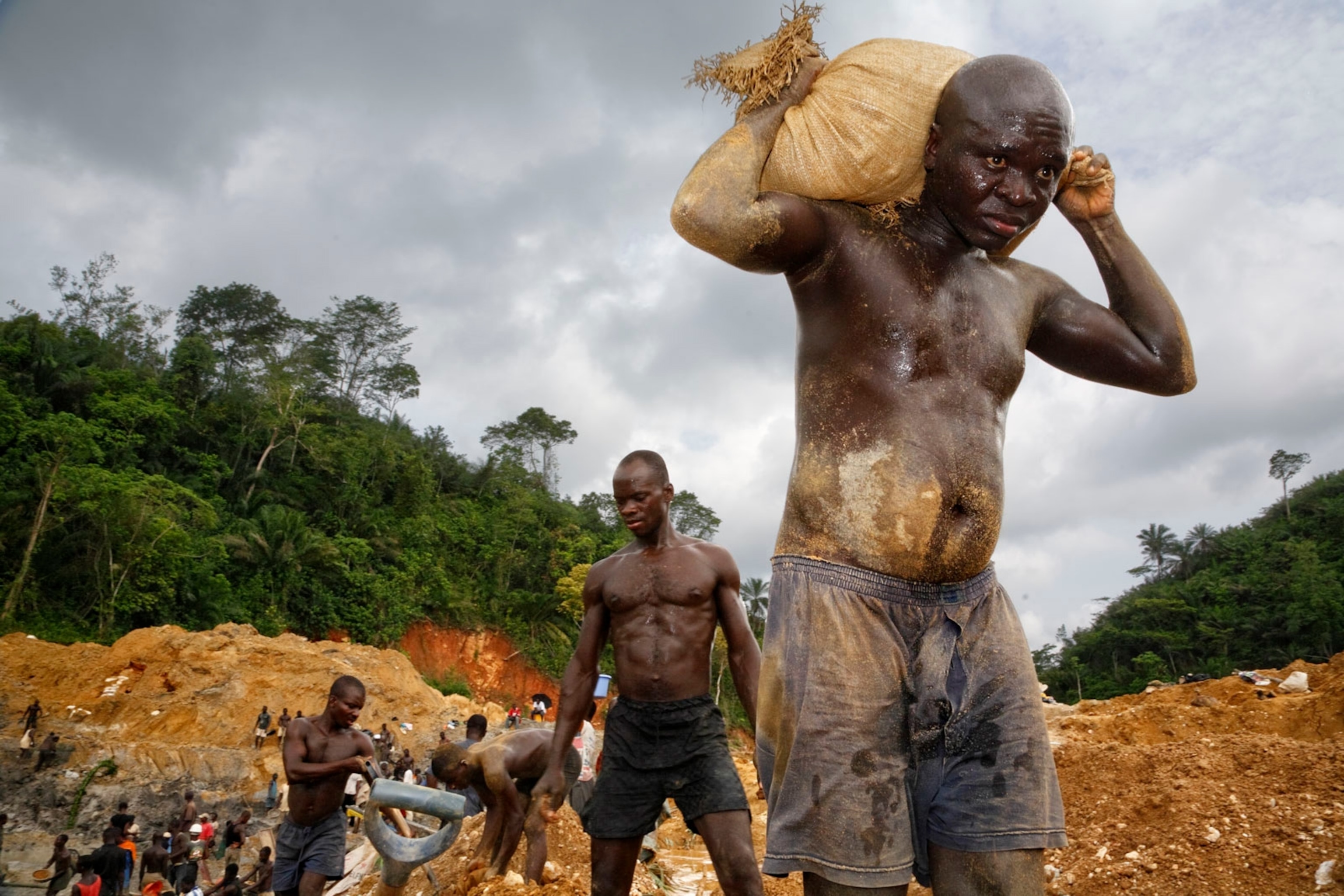 illegal miners clawing sacks of gold ore from the Pra River in Ghana