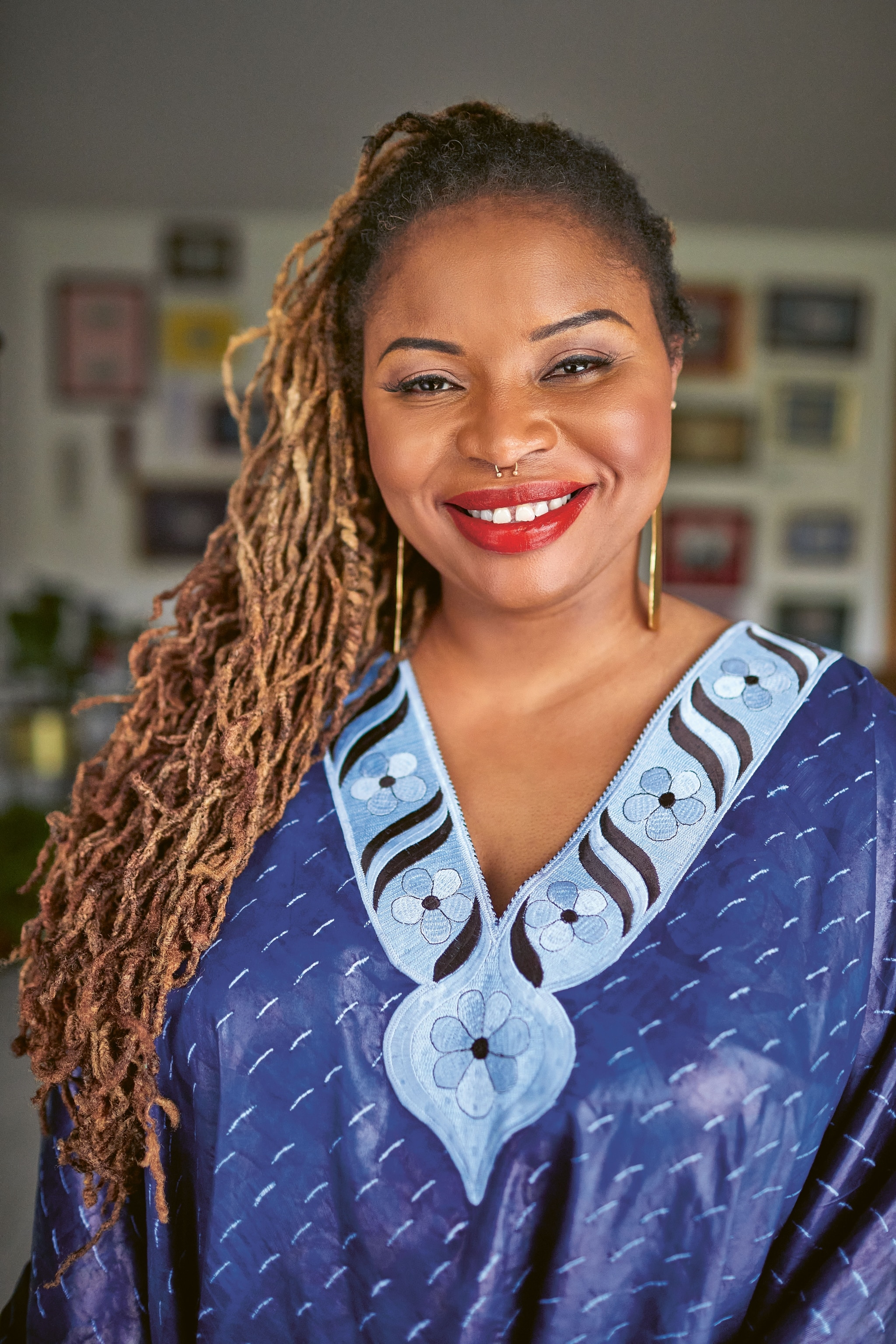 image of woman with red lipstick, gold earrings, in a blue dress