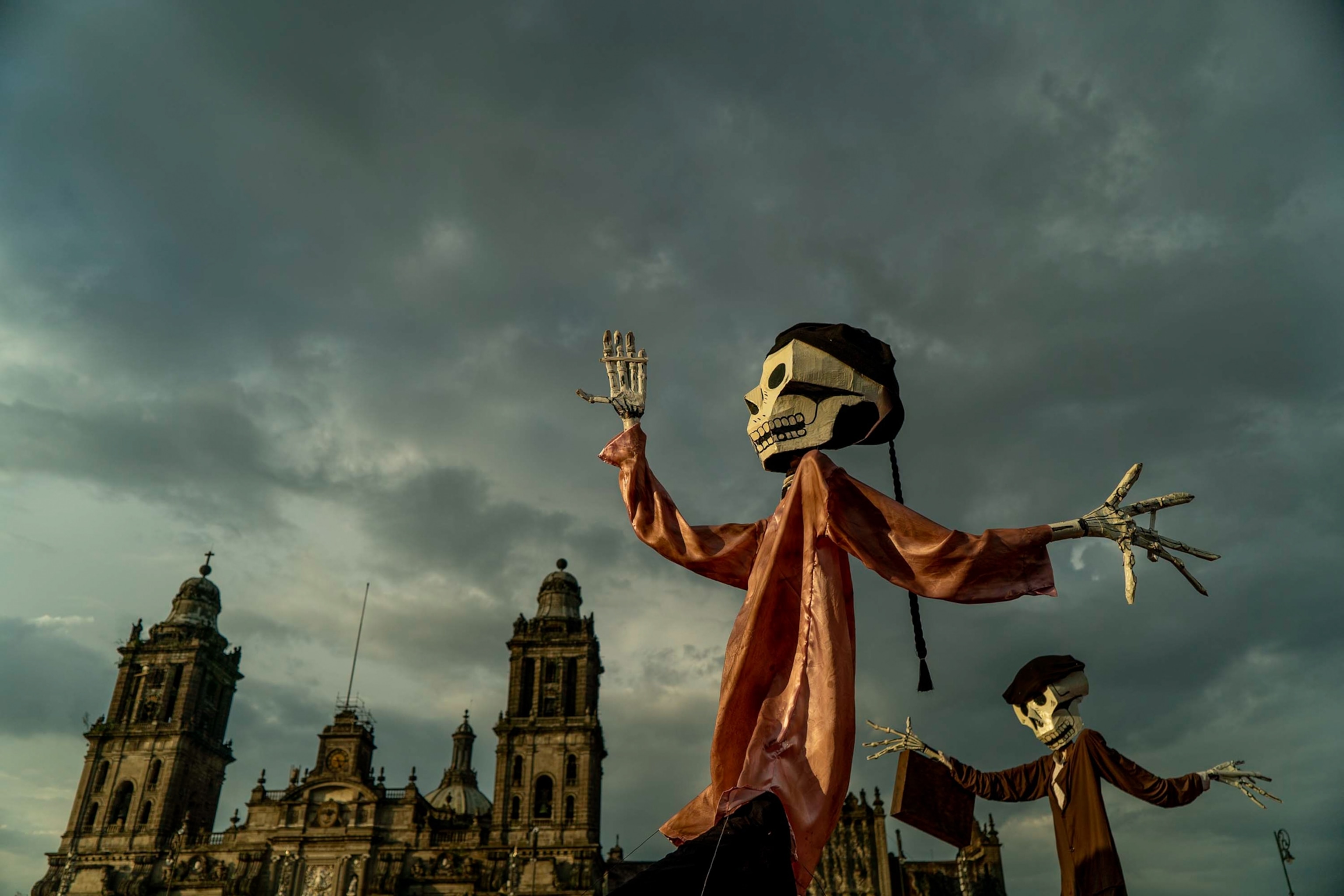 Skeleton statues are seen against the sky in Mexico City