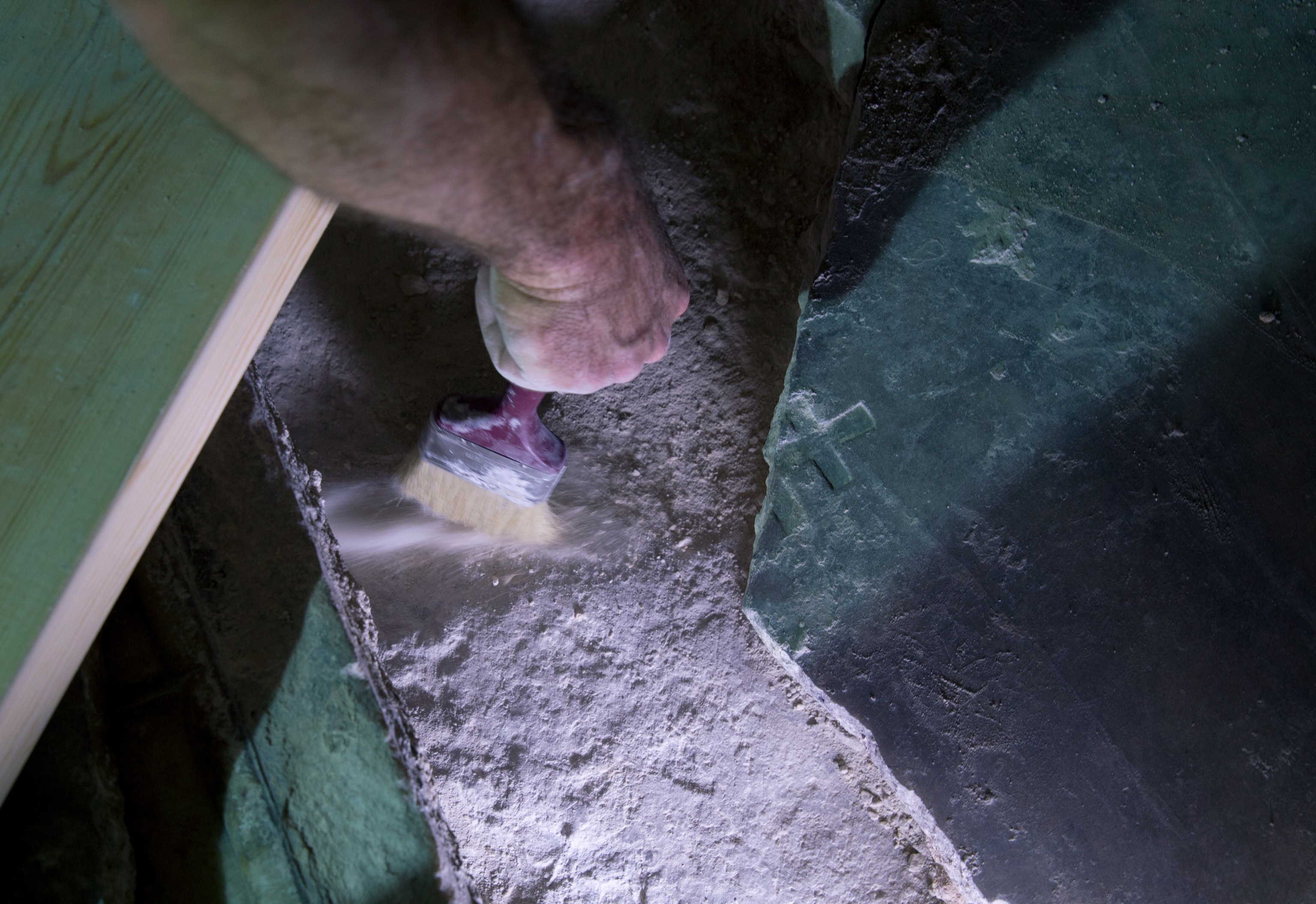 archaeologist brushing off the original slab.