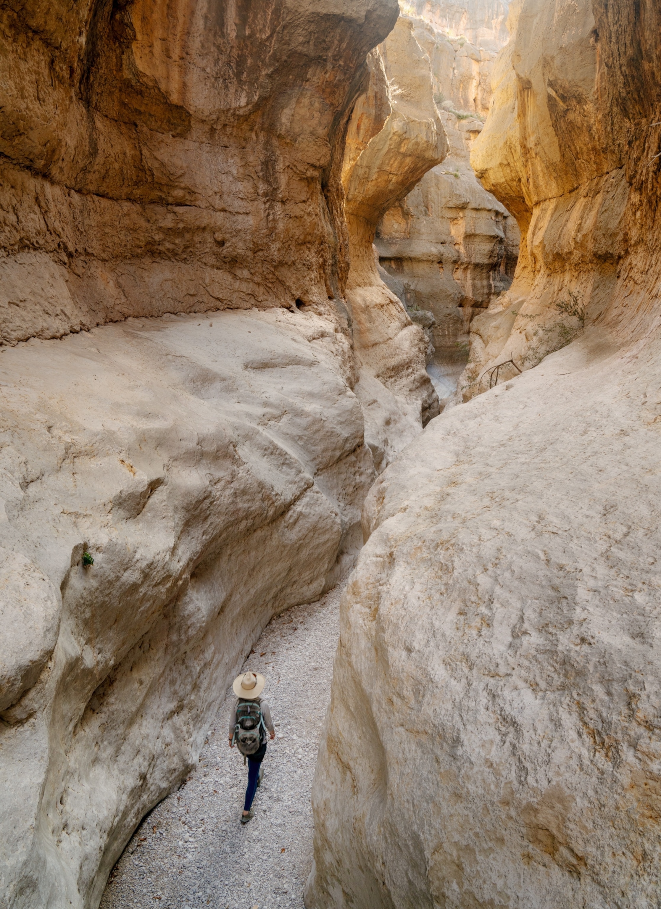 High angle view of a hiker walking through a narrow canyon.