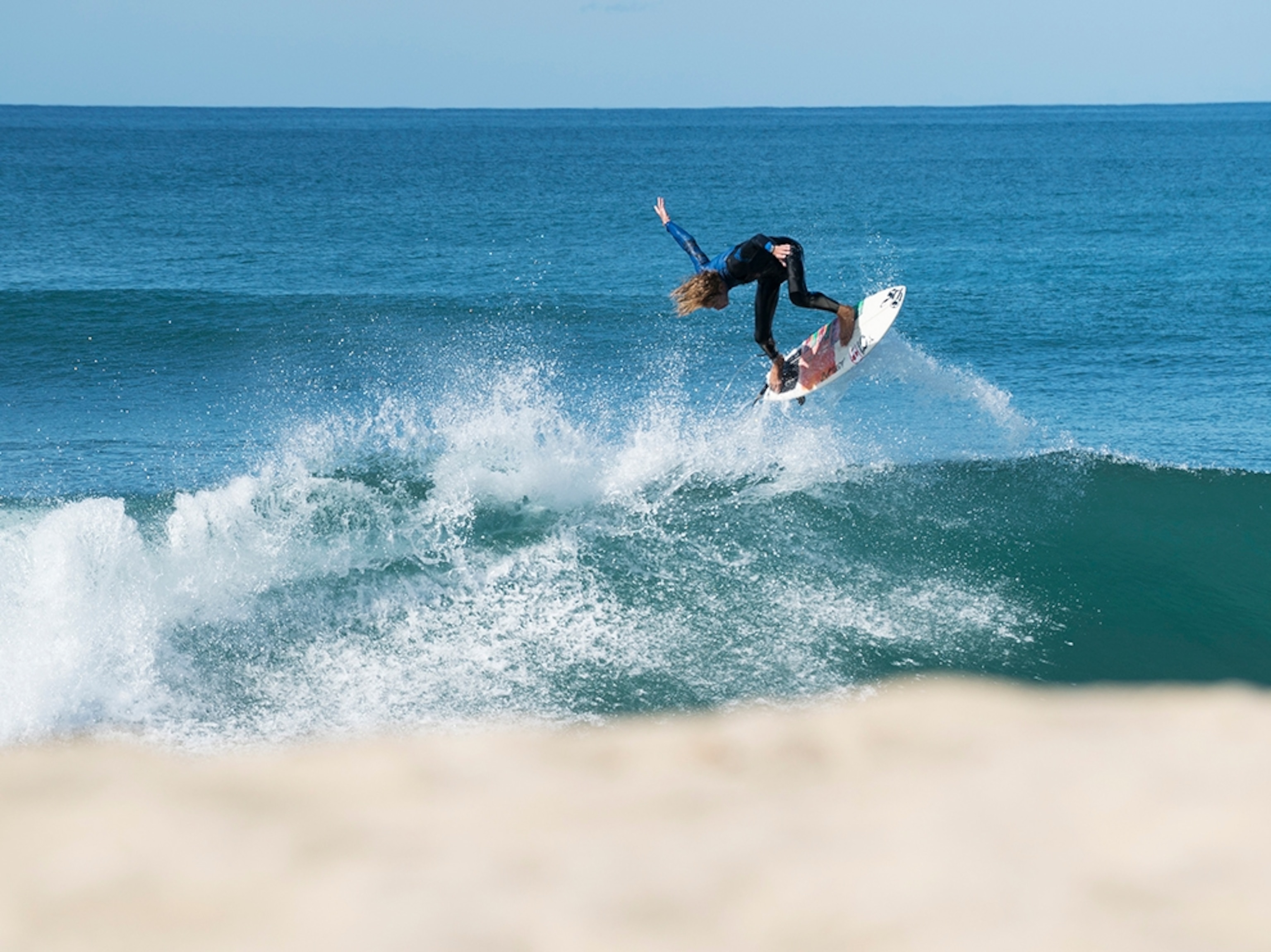 a surfer catching air over a wave in Baja, Mexico