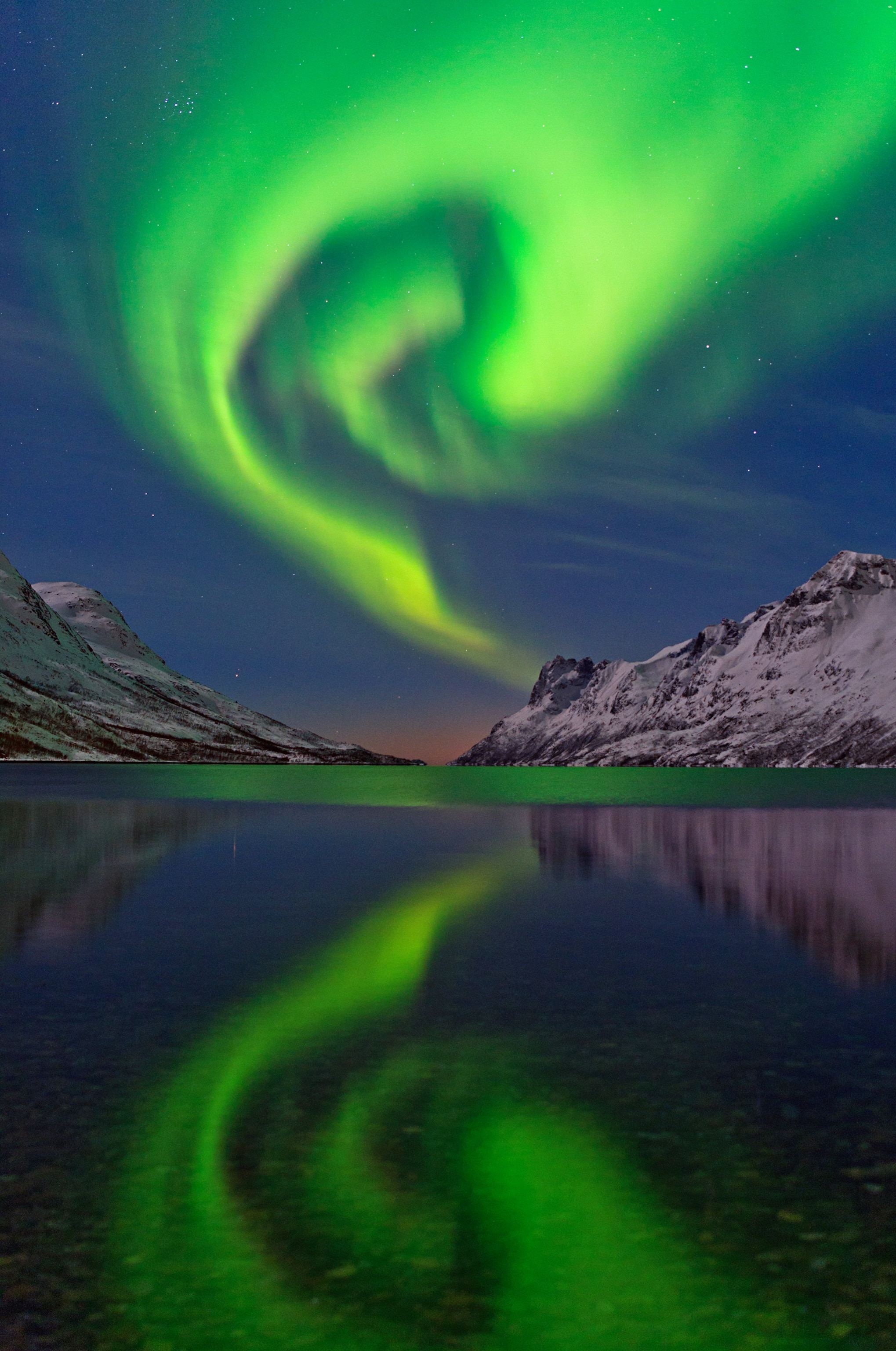 an aurora above a fjord near Tromso, Norway