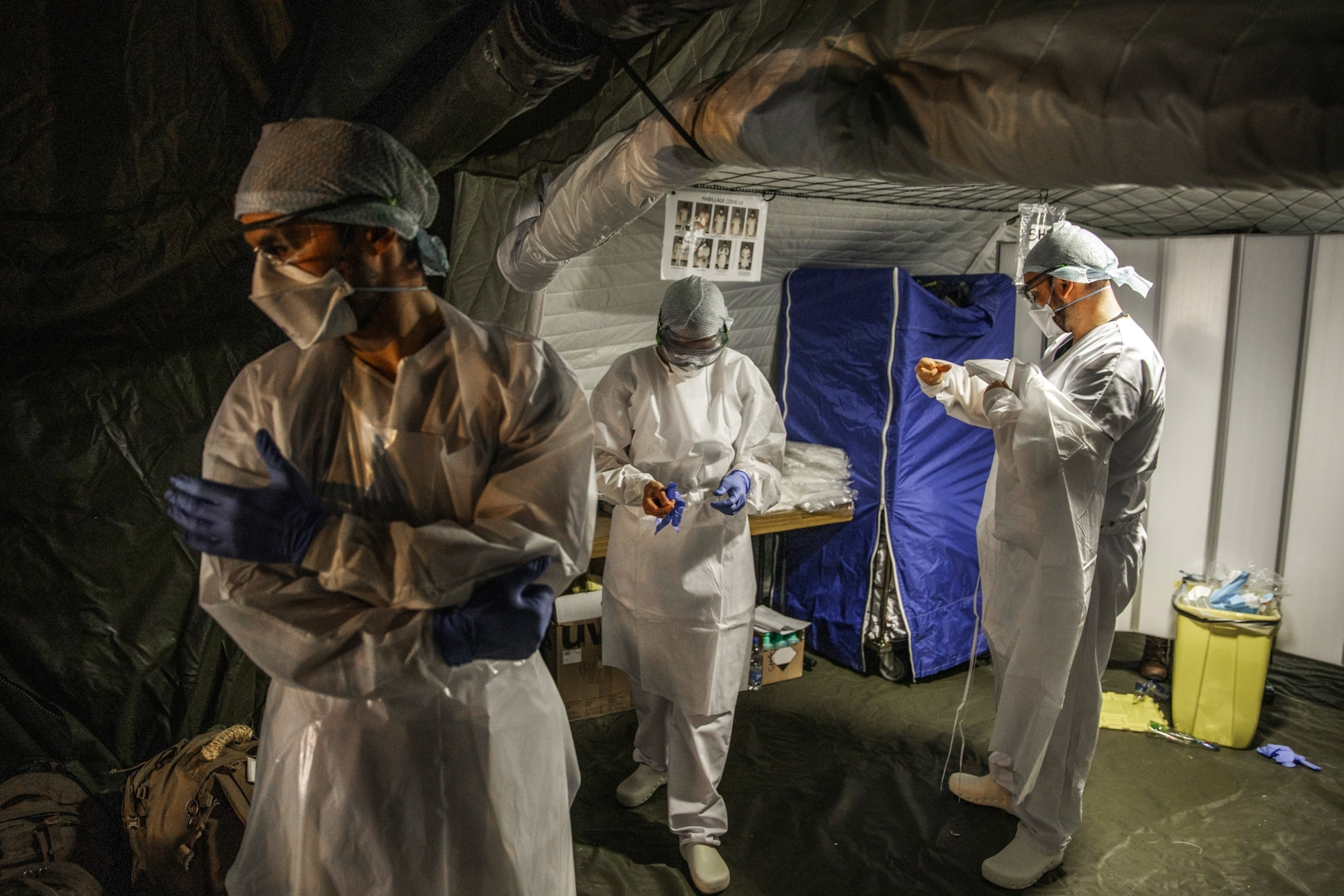 doctors in protective clothing preparing in a room