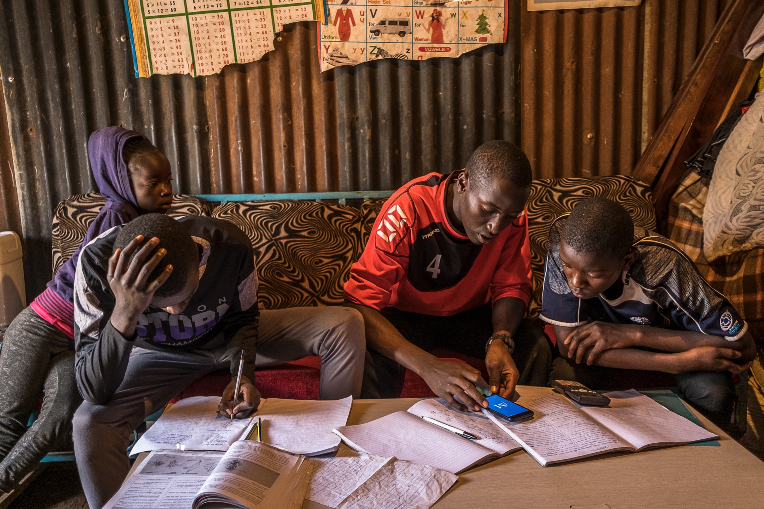 siblings help each other with schoolwork in Nairobi during Covid-19