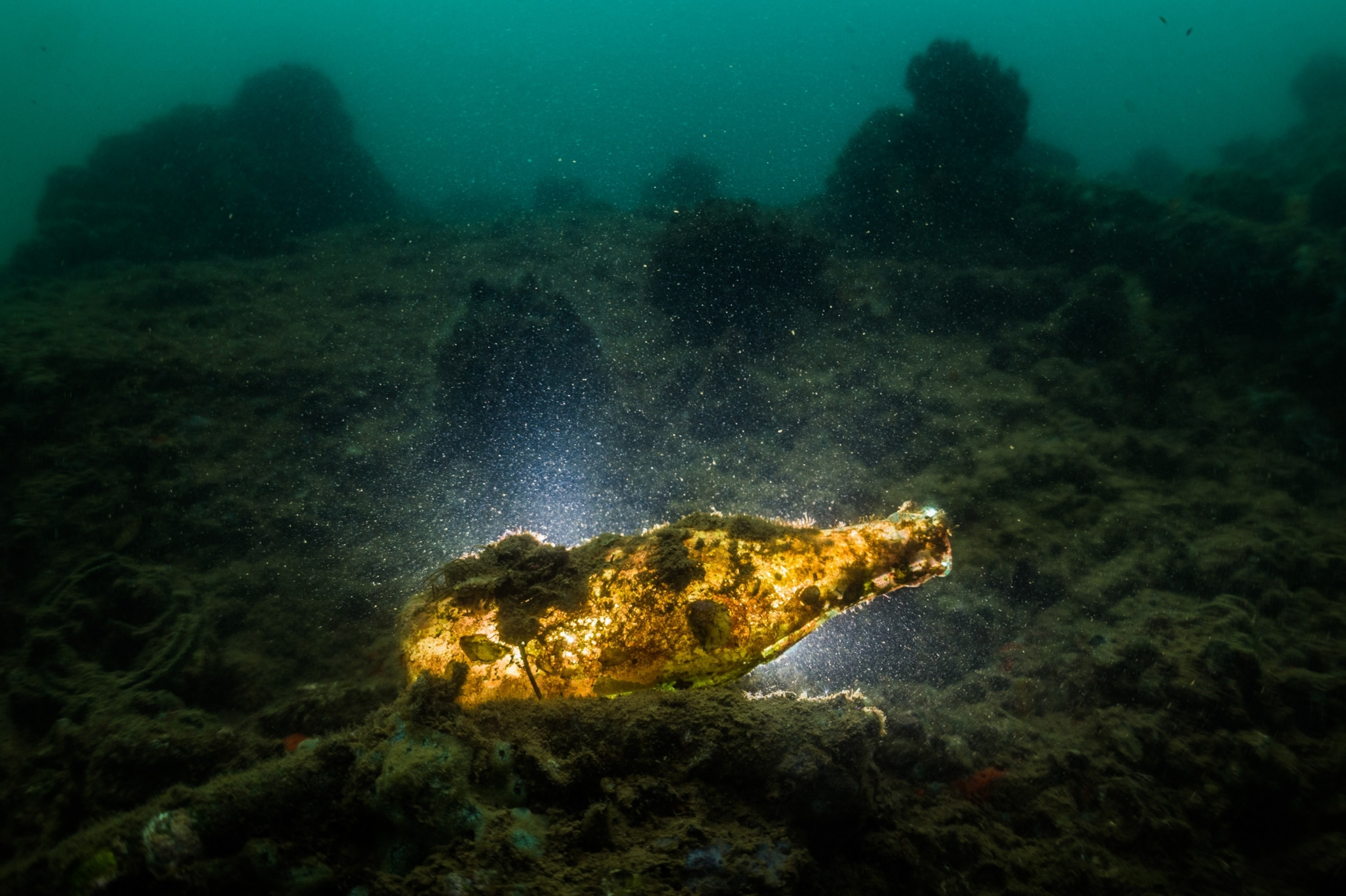 glass bottle on ocean floor