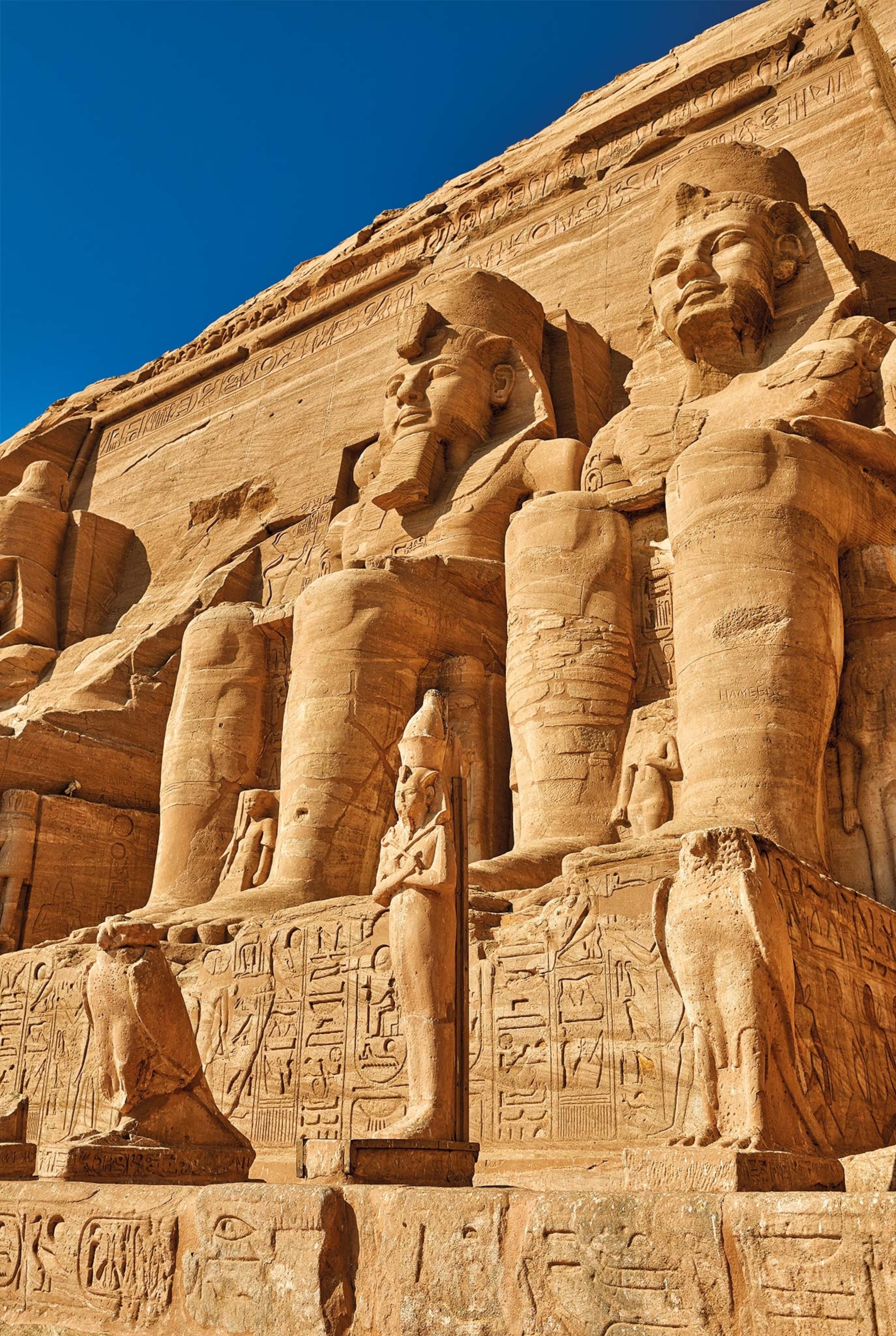 The main facade of the great temple of Ramses II at Abu Simbel is decorated with four colossi of the king, with effigies of his wives and daughters at his feet.